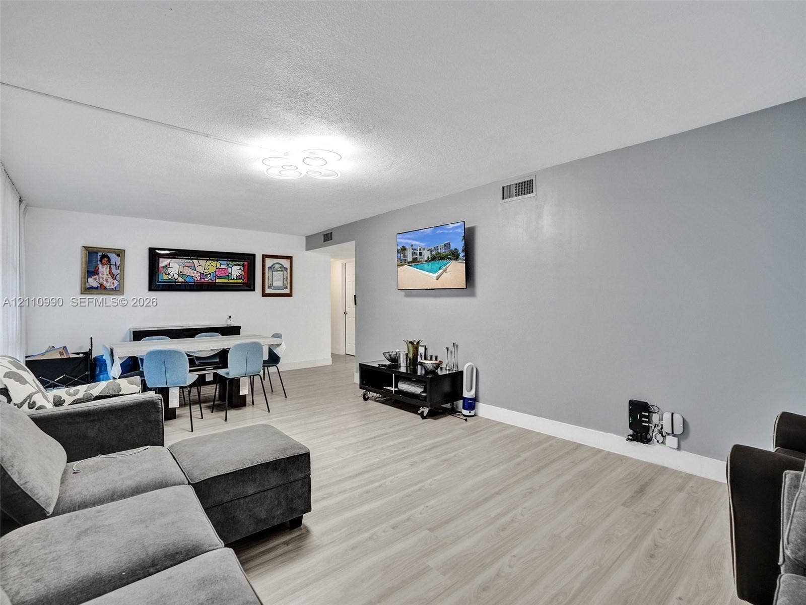 800 Parkview Drive, #131, Hallandale Beach, FL 33009 Open-concept interior featuring wood-finish flooring, neutral wall tones, and modern circular flush-mount ceiling lighting