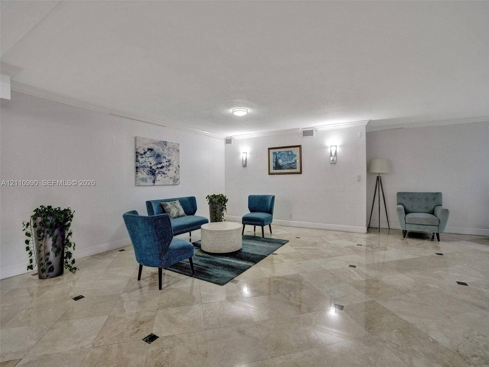800 Parkview Drive, #131, Hallandale Beach, FL 33009 Polished stone flooring with decorative inset accents, crown molding, and wall-mounted light fixtures
