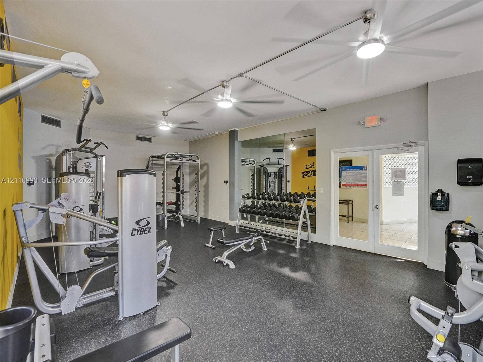 800 Parkview Drive, #131, Hallandale Beach, FL 33009 Fitness area featuring durable rubber flooring, mirrored walls, and multiple ceiling-mounted fans