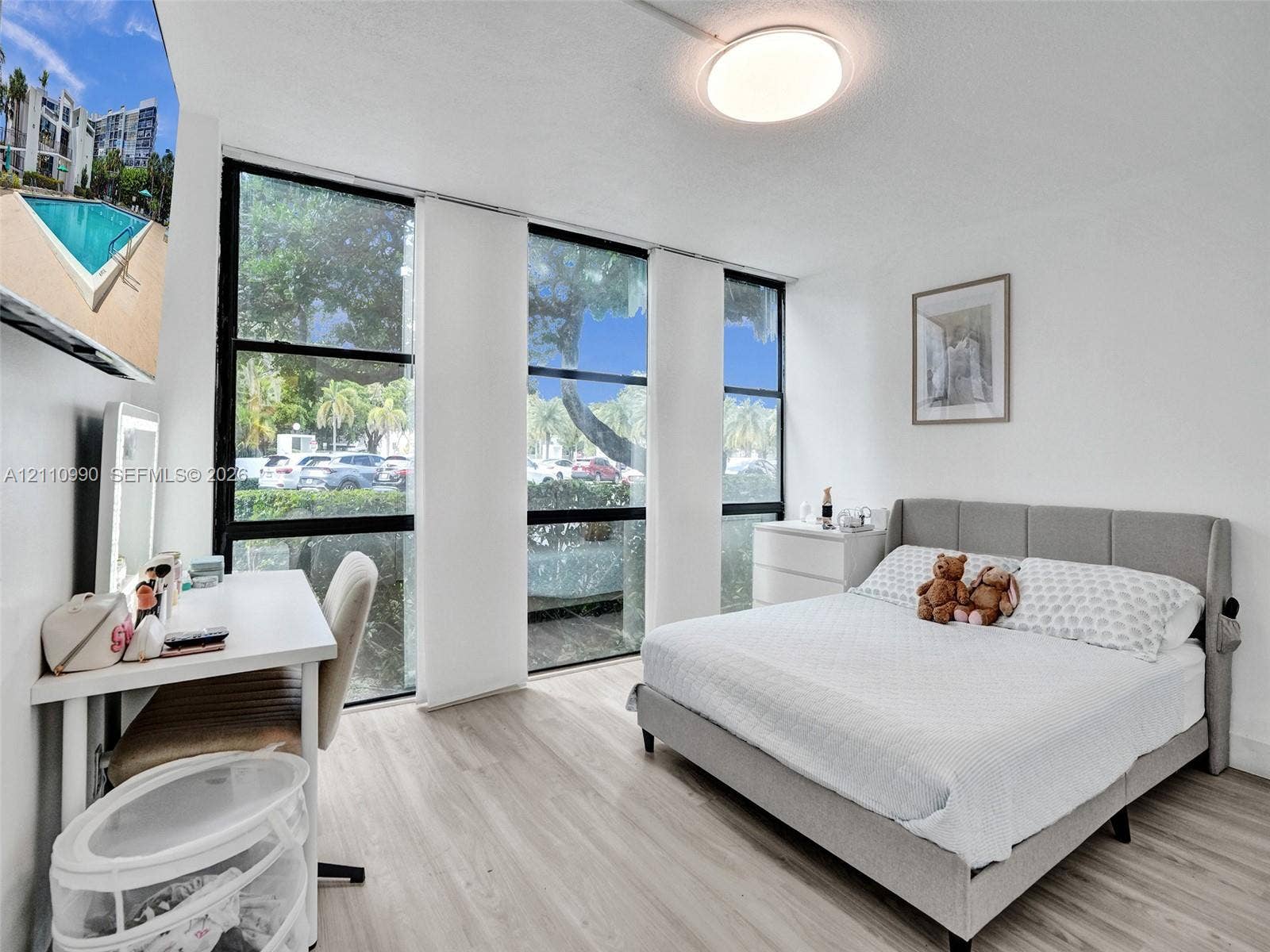800 Parkview Drive, #131, Hallandale Beach, FL 33009 Floor-to-ceiling windows with black frames, wood-finish flooring, and a flush-mount circular ceiling light