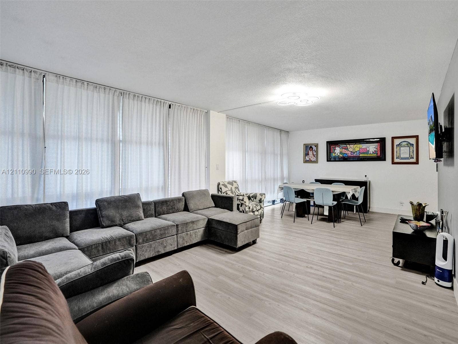 800 Parkview Drive, #131, Hallandale Beach, FL 33009 Spacious interior featuring full-height floor-to-ceiling windows, light-toned wood-finish flooring, and modern flush-mount overhead lighting