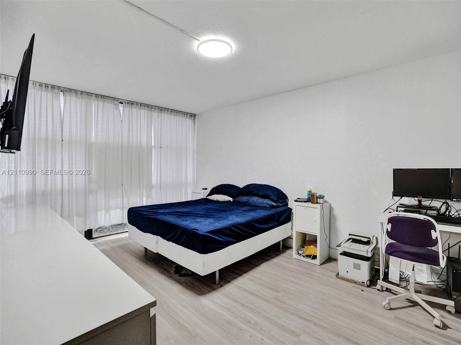 800 Parkview Drive, #131, Hallandale Beach, FL 33009 Interior space featuring light-toned wood-finish flooring, floor-to-ceiling window treatments, and a central flush-mount LED light fixture