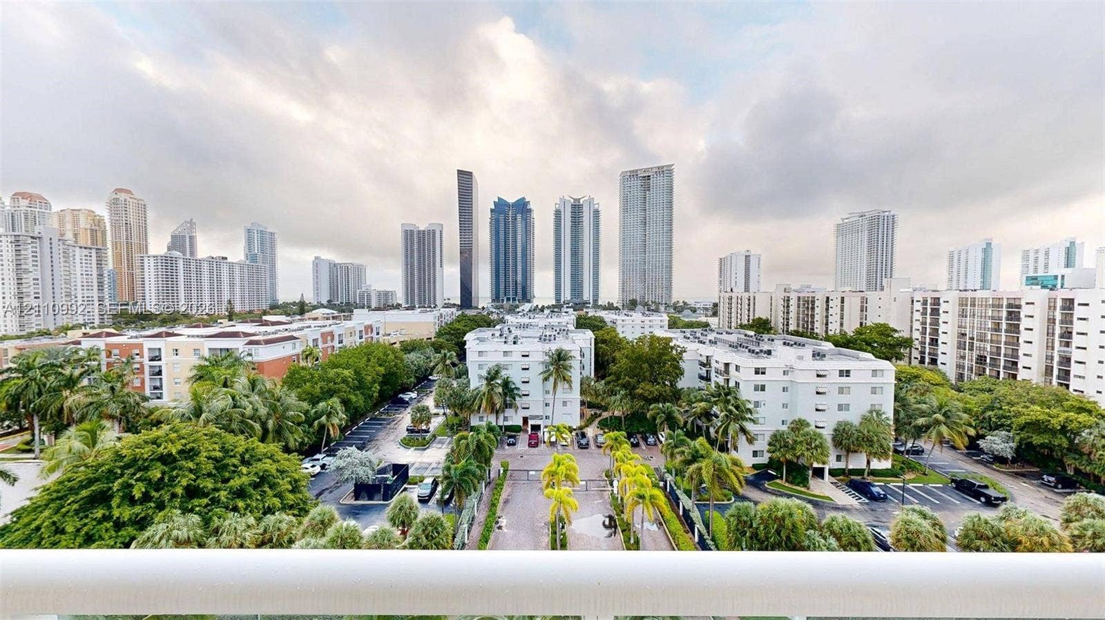 Elevated balcony featuring a white railing and expansive skyline scenery