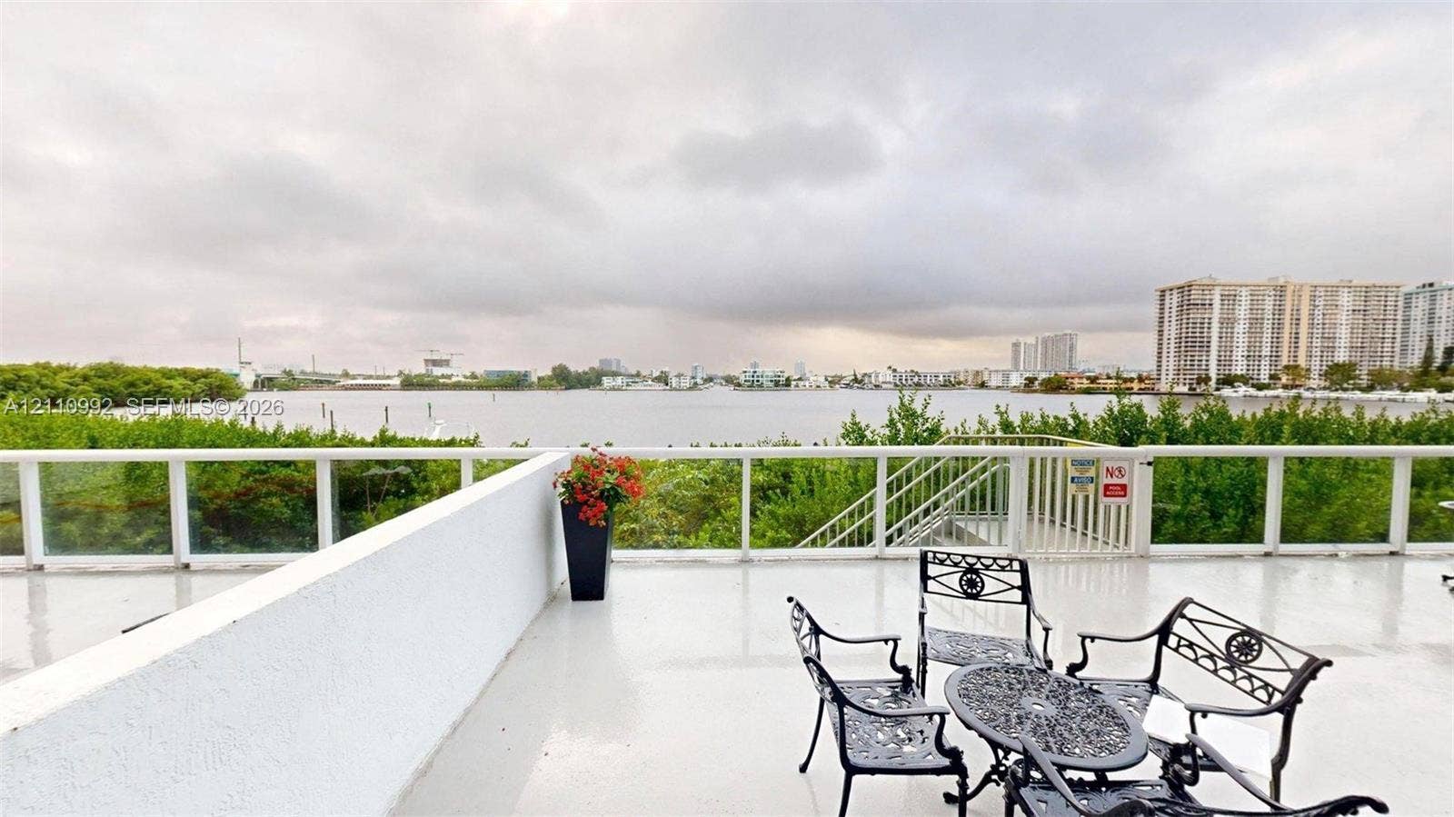 Expansive open-air deck featuring a smooth surface finish, structural white railing, and a gate