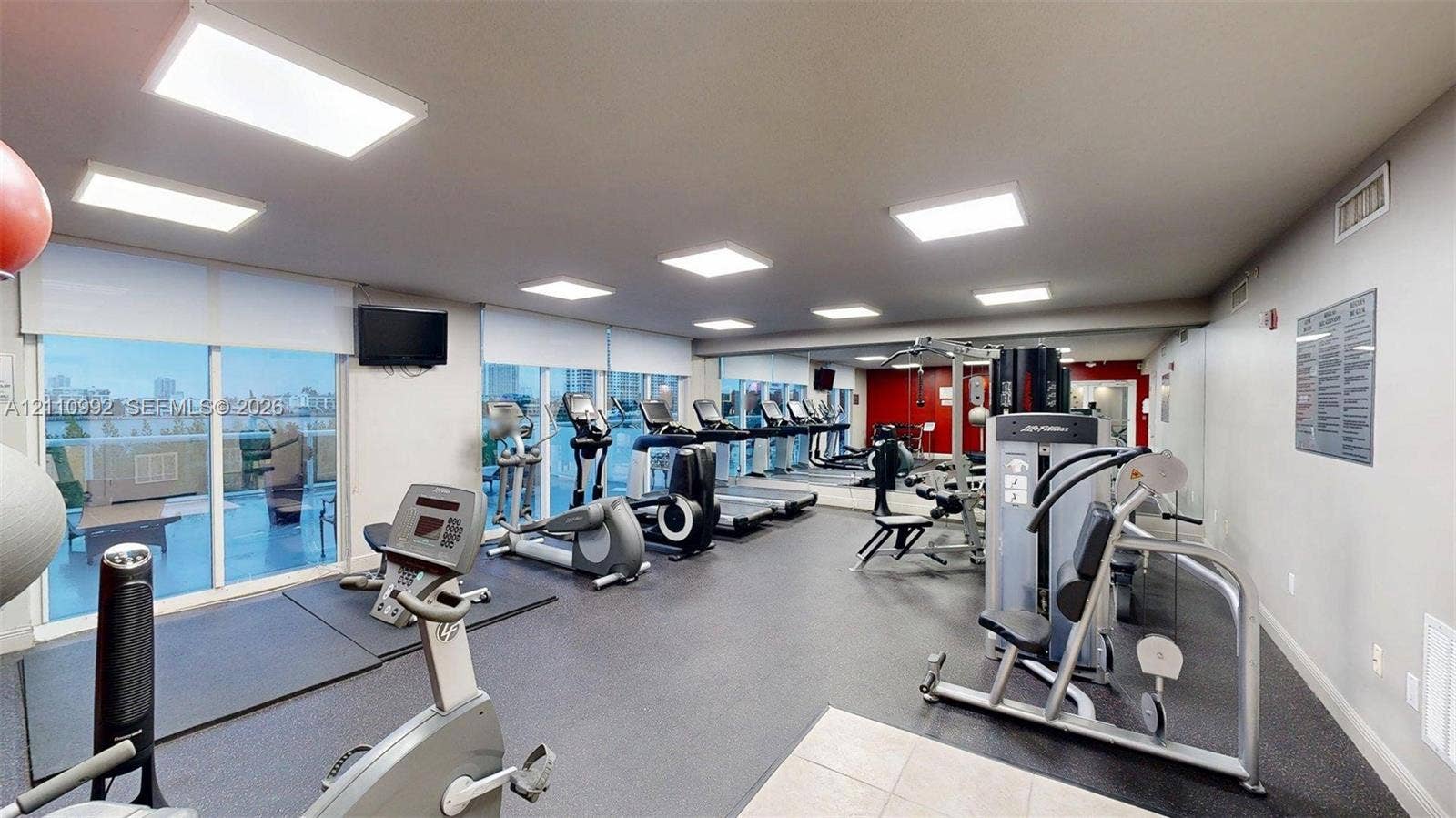 Fitness center featuring rubber flooring, recessed lighting, wall-to-wall mirrors, and floor-to-ceiling windows