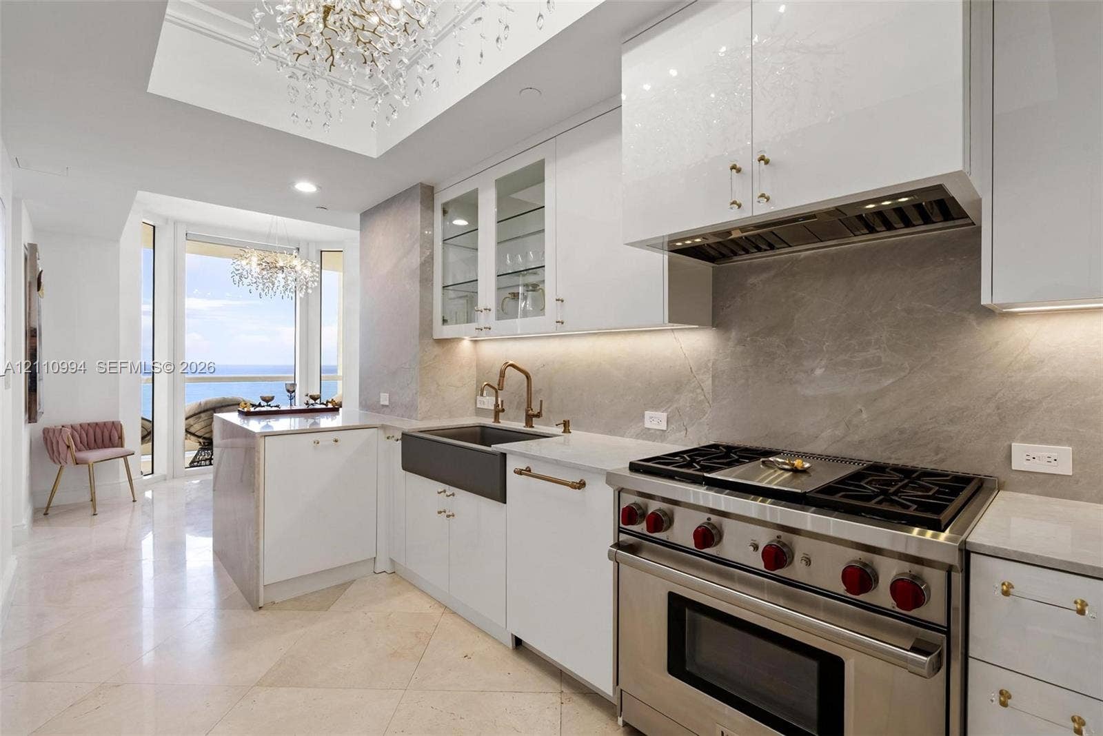 17875 Collins Avenue, #2405, Sunny Isles Beach, Sunny Isles Beach, FL 33160 Chefs kitchen featuring custom white cabinetry, stone slab backsplash, farmhouse-style apron sink, professional-grade stainless steel range, and stone flooring