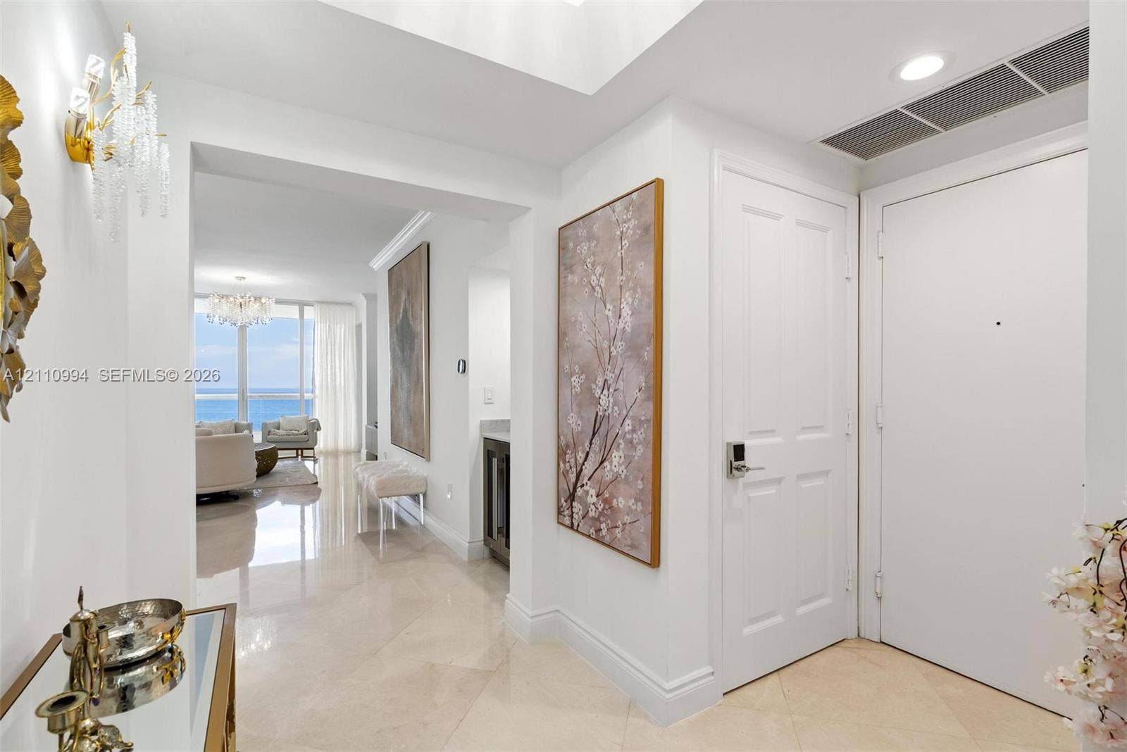 17875 Collins Avenue, #2405, Sunny Isles Beach, Sunny Isles Beach, FL 33160 Entryway featuring polished stone flooring, recessed ceiling lighting, a crystal wall sconce, and high-gloss multi-panel doors