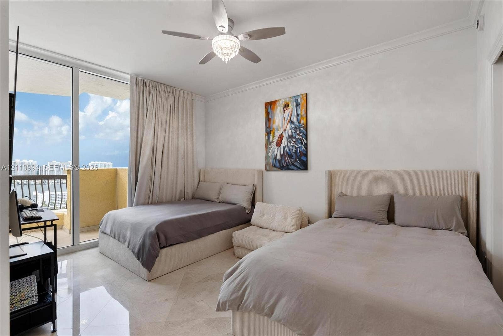 17875 Collins Avenue, #2405, Sunny Isles Beach, Sunny Isles Beach, FL 33160 Floor-to-ceiling glass sliding doors opening to a balcony, polished stone flooring, crown molding, and a central ceiling fan with an integrated light fixture
