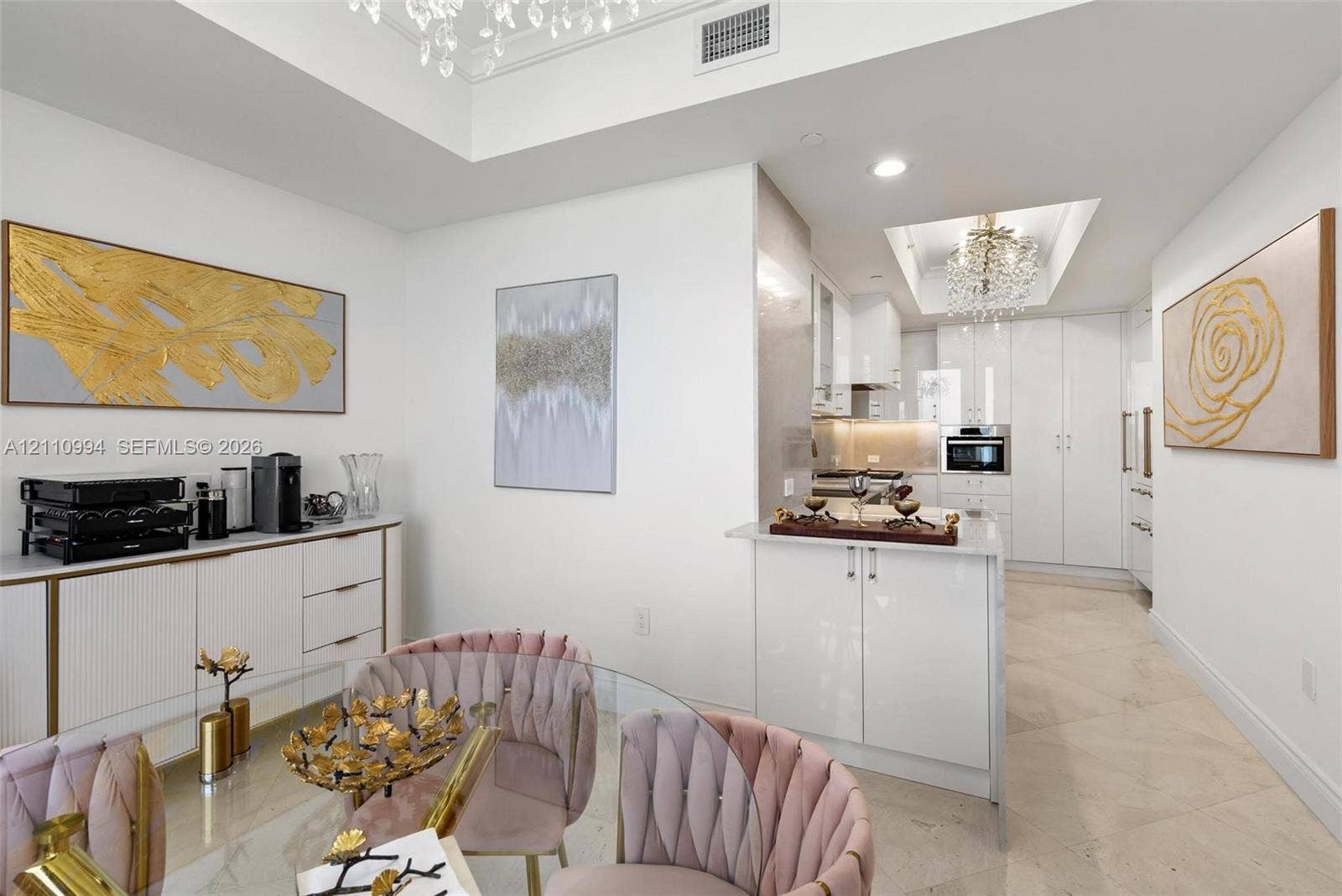 17875 Collins Avenue, #2405, Sunny Isles Beach, Sunny Isles Beach, FL 33160 Kitchen featuring high-gloss cabinetry, stone tile flooring, tray ceilings with crystal chandeliers, and a built-in buffet