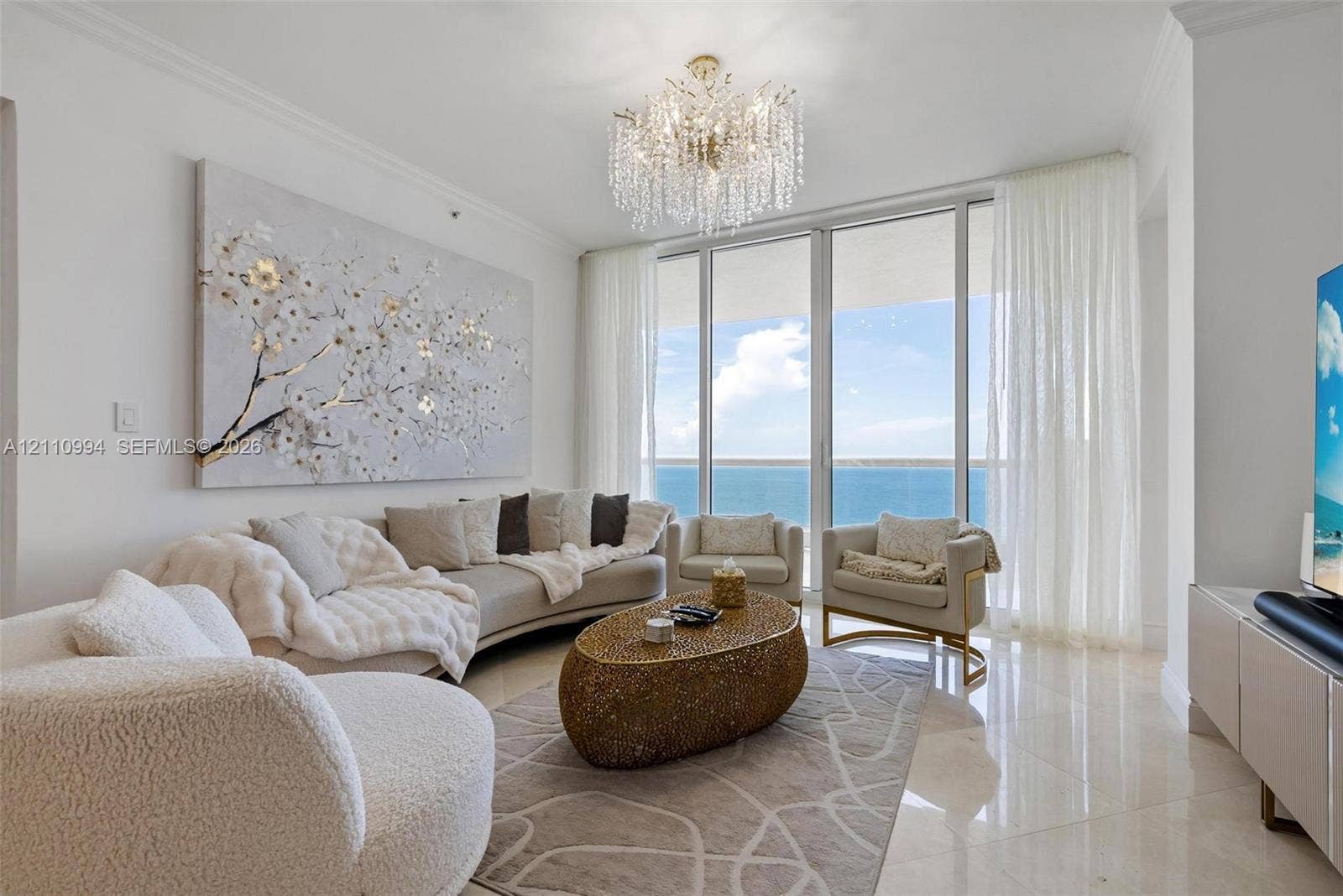 17875 Collins Avenue, #2405, Sunny Isles Beach, Sunny Isles Beach, FL 33160 Floor-to-ceiling windows featuring ocean panoramas, polished tile flooring, and a tiered crystal chandelier