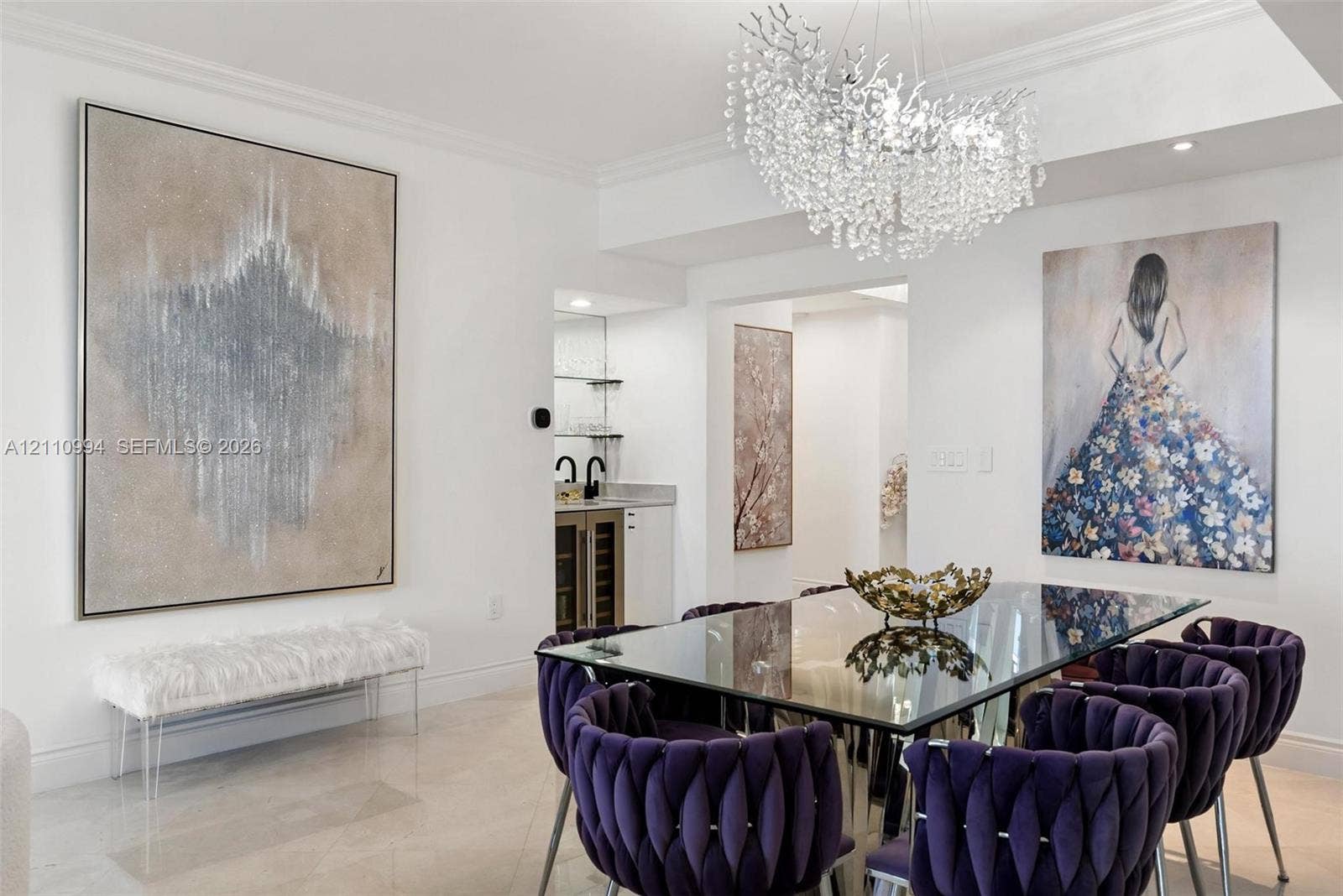 17875 Collins Avenue, #2405, Sunny Isles Beach, Sunny Isles Beach, FL 33160 Statement chandelier with crystal accents, polished stone flooring, and a built-in wet bar featuring cabinetry, glass shelving, and a beverage refrigerator