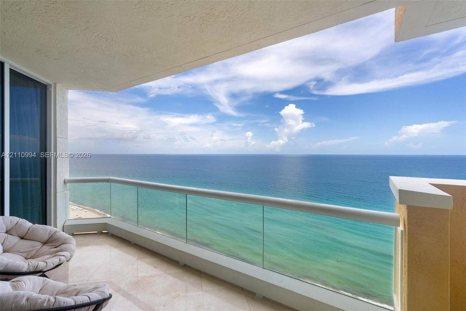 17875 Collins Avenue, #2405, Sunny Isles Beach, Sunny Isles Beach, FL 33160 Covered balcony featuring tile flooring and a glass panel railing with a horizontal metal top rail