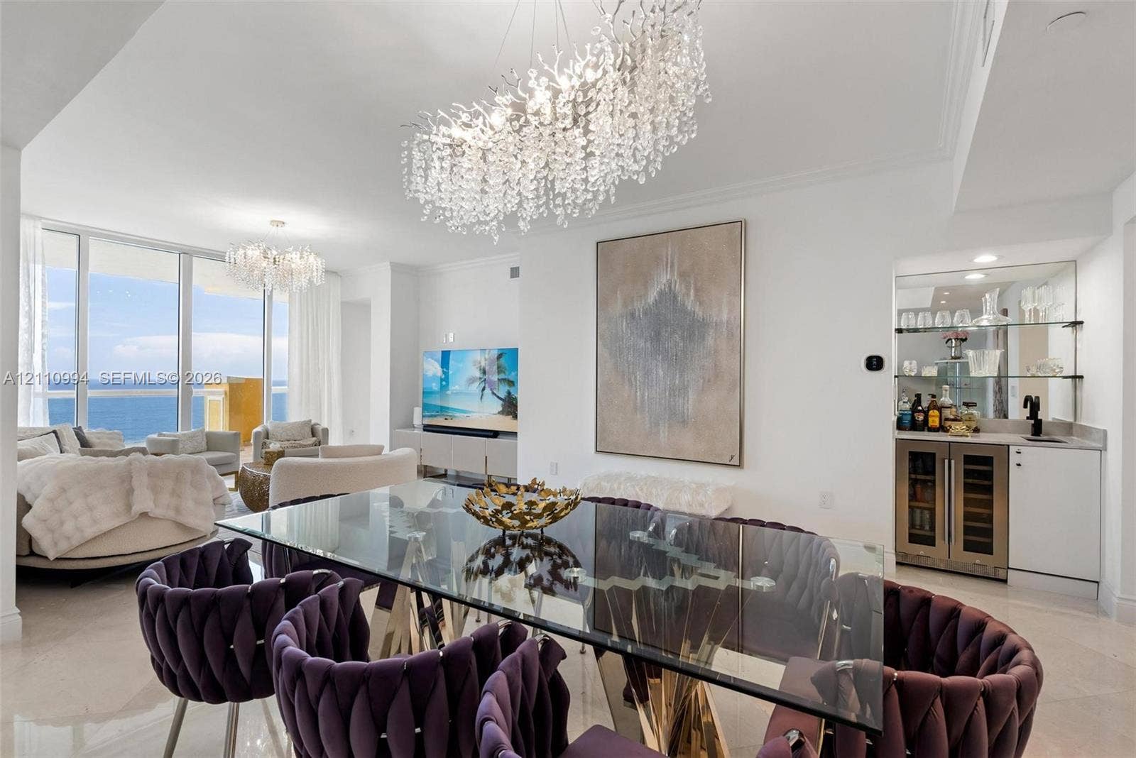 17875 Collins Avenue, #2405, Sunny Isles Beach, Sunny Isles Beach, FL 33160 Open-concept space featuring floor-to-ceiling glass, custom crystal chandeliers, polished stone flooring, and a built-in wet bar with a glass-front beverage cooler