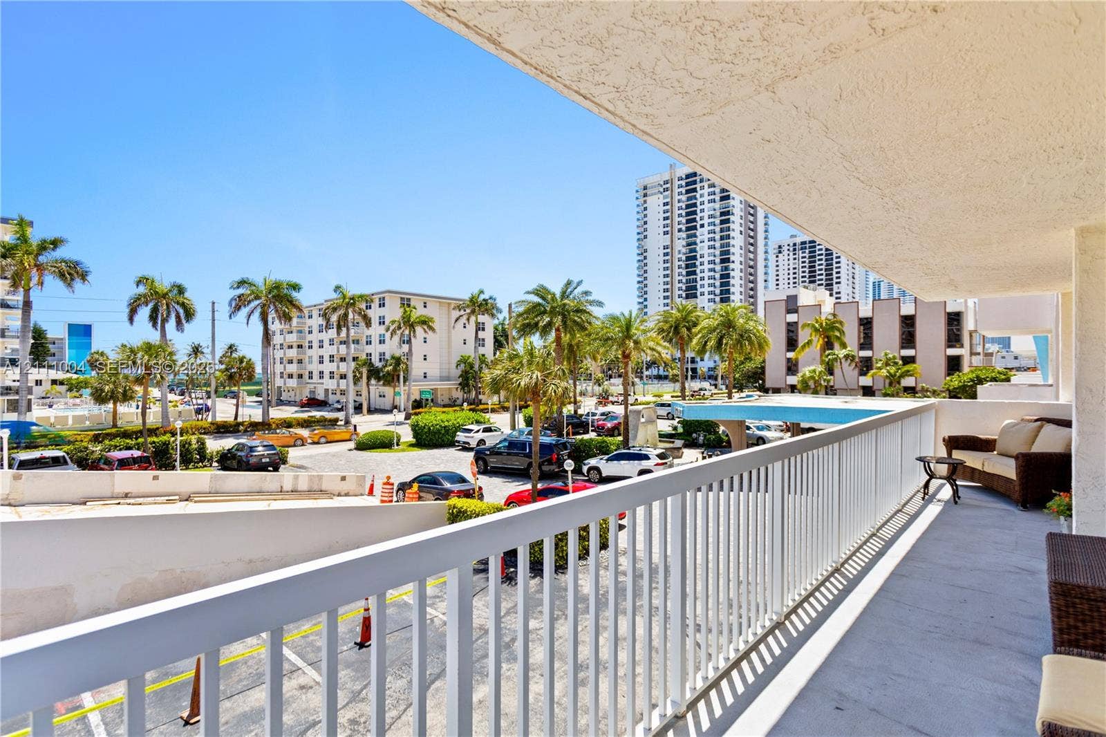 Covered balcony featuring concrete flooring and a white metal railing