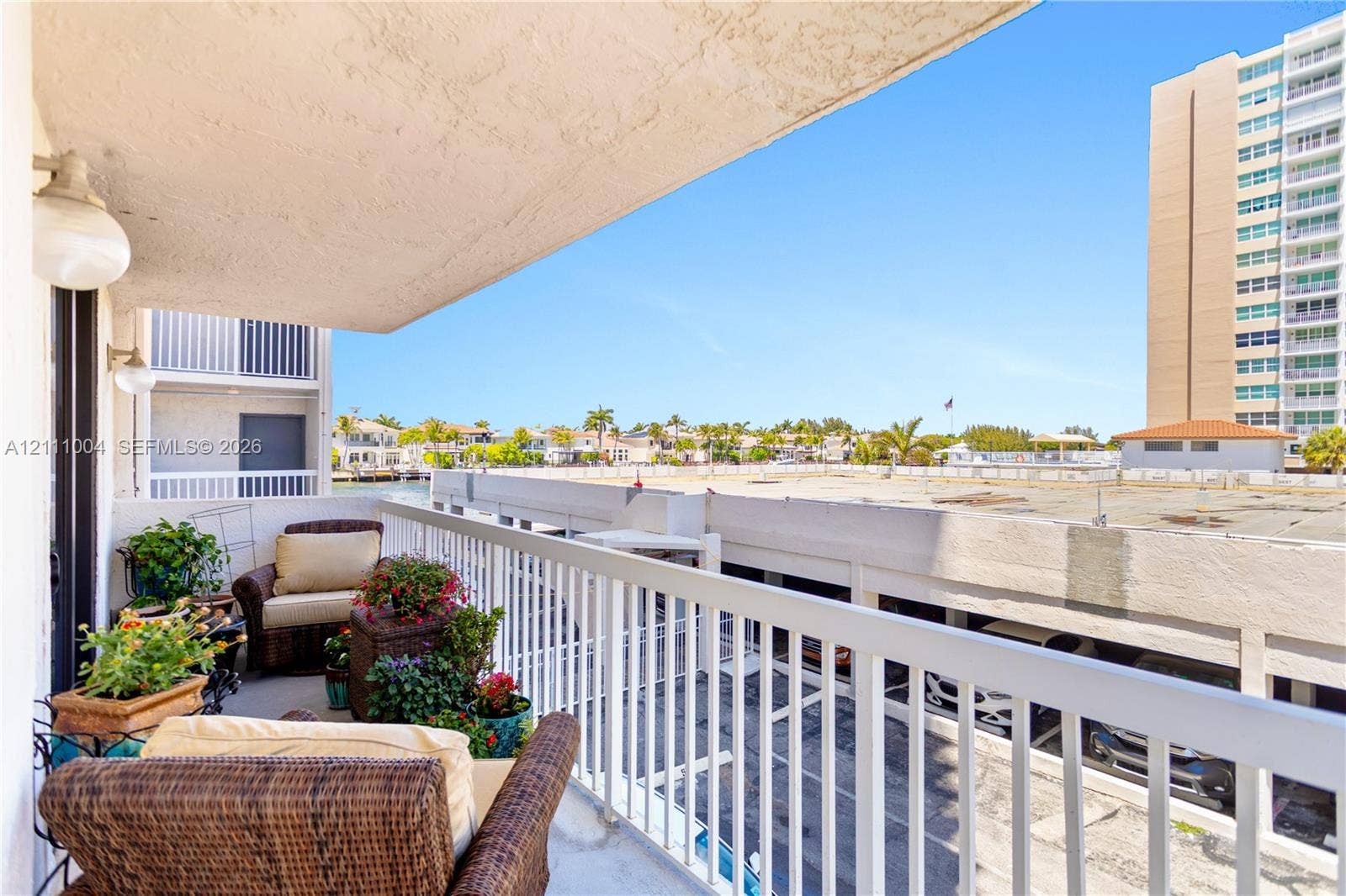 Covered balcony featuring white metal railings and wall-mounted exterior lighting
