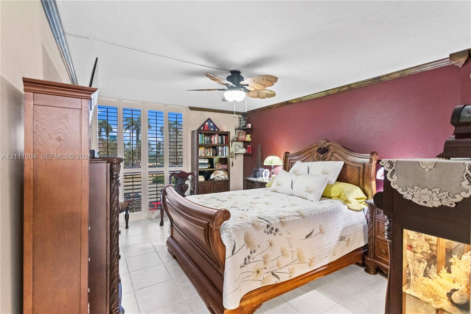 Room featuring tile flooring, ceiling fan with light fixture, and floor-to-ceiling plantation shutters