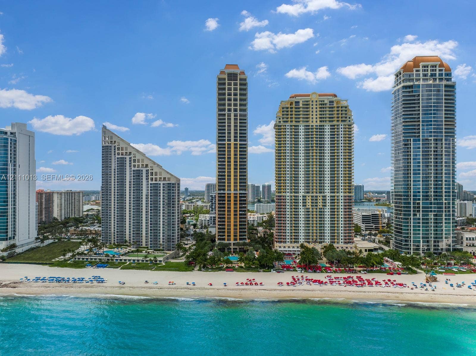 High-rise residential architecture featuring glass facades, expansive balcony levels, and direct coastal access