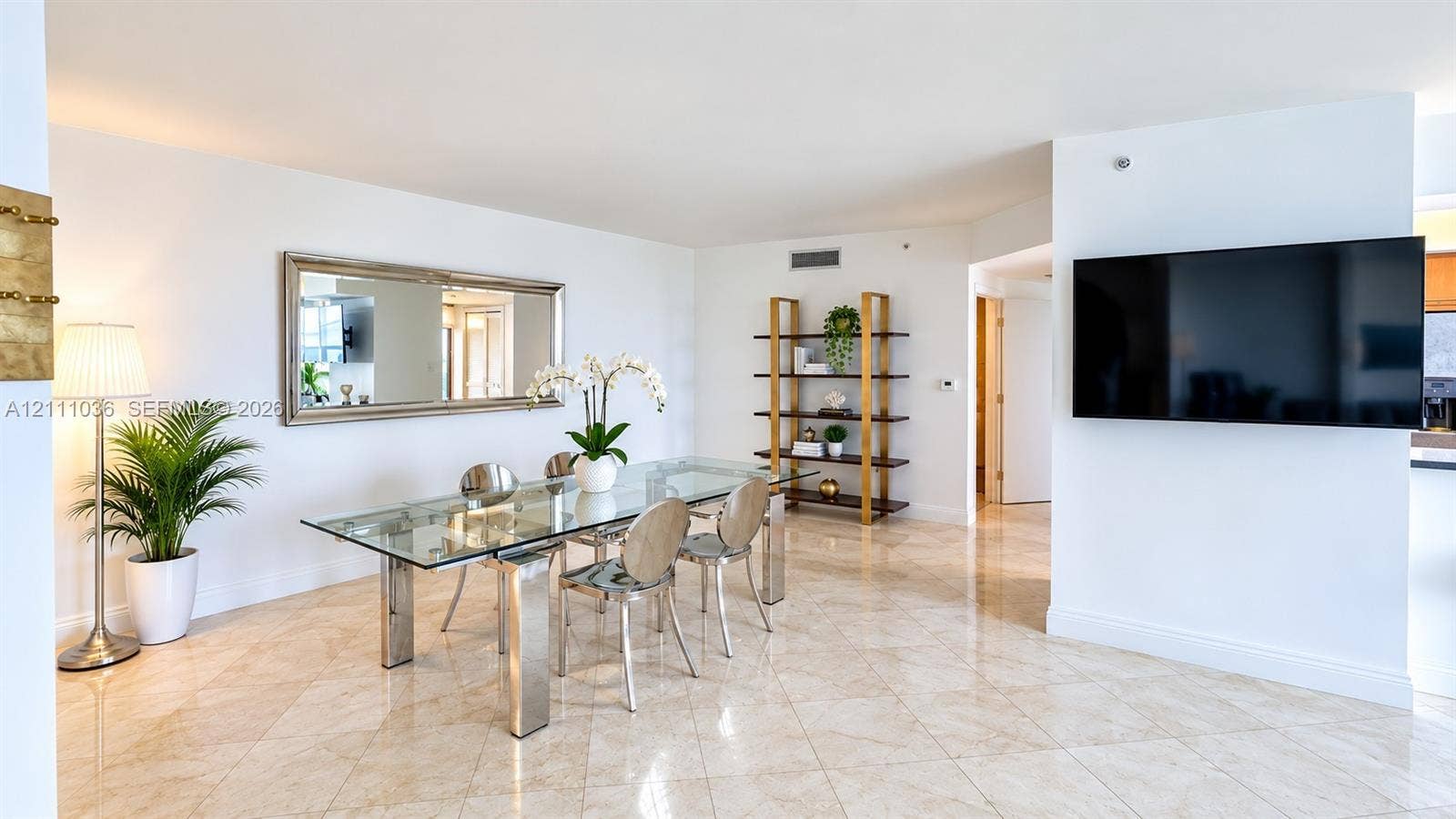6365 Collins Avenue, #3811, Miami Beach, FL 33141 Open-concept dining area featuring polished stone tile flooring, neutral wall finishes, and a decorative wall-mounted mirror