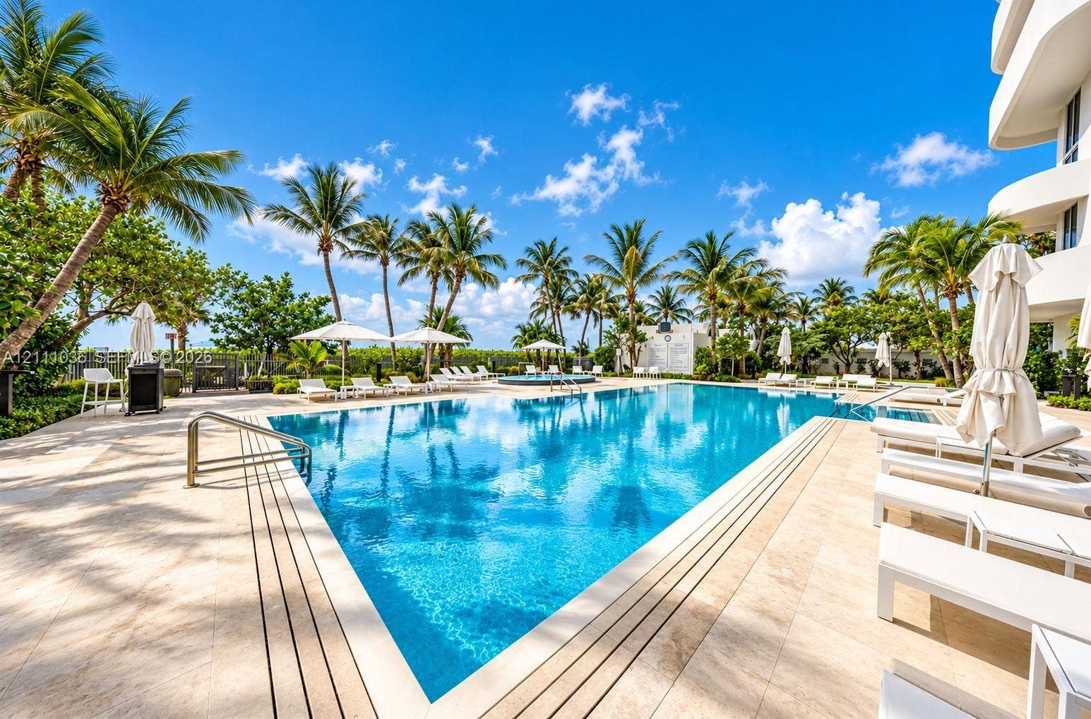6365 Collins Avenue, #3811, Miami Beach, FL 33141 Swimming pool featuring stone decking, metal handrails, and mature palm trees