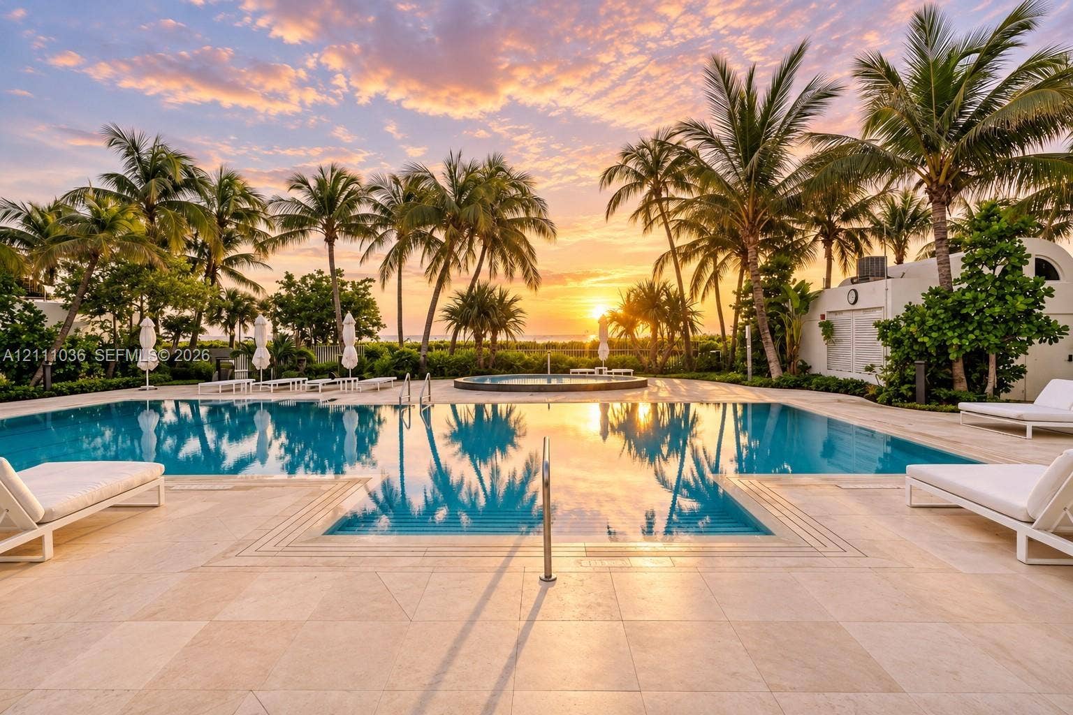 6365 Collins Avenue, #3811, Miami Beach, FL 33141 Swimming pool with a raised circular spa, expansive stone-paver pool deck, and mature palm tree landscaping