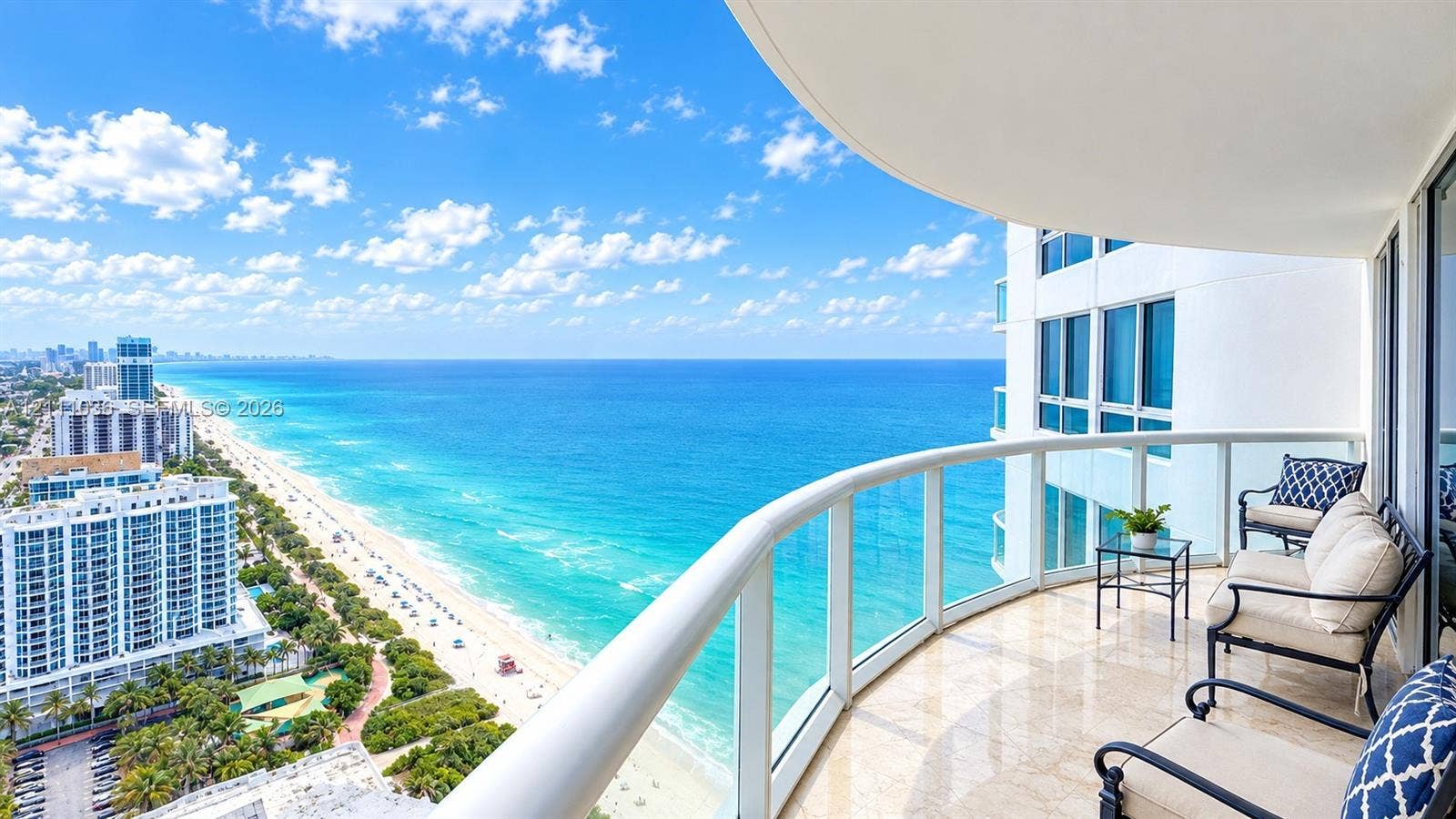 6365 Collins Avenue, #3811, Miami Beach, FL 33141 Covered balcony featuring natural stone flooring, glass panel railings, and expansive ocean scenery