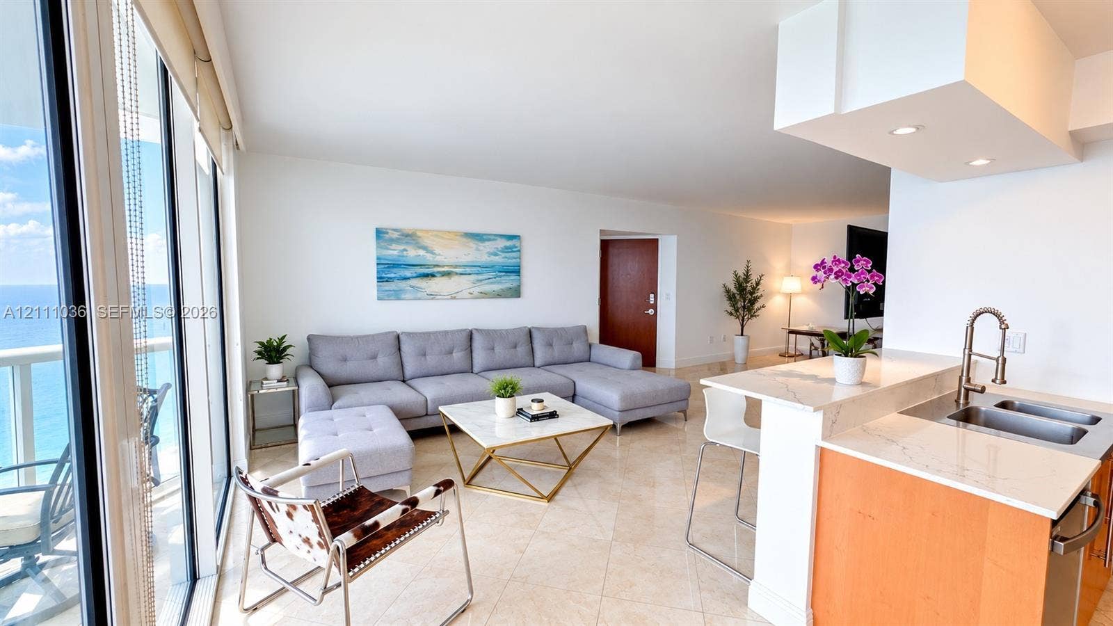 6365 Collins Avenue, #3811, Miami Beach, FL 33141 Open-concept living space featuring floor-to-ceiling windows, natural stone flooring, kitchen peninsula with a quartz countertop, and recessed lighting