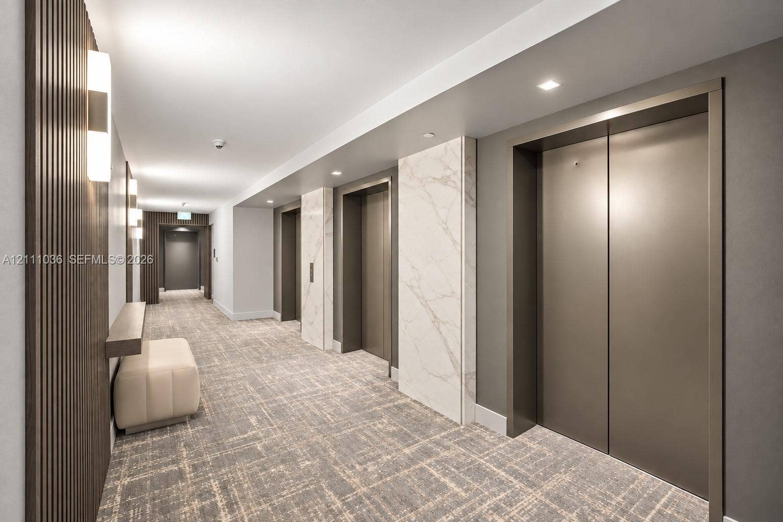6365 Collins Avenue, #3811, Miami Beach, FL 33141 Elevator lobby featuring metallic-finish elevator doors, floor-to-ceiling stone-clad surround, wood-slat accent wall, and recessed lighting