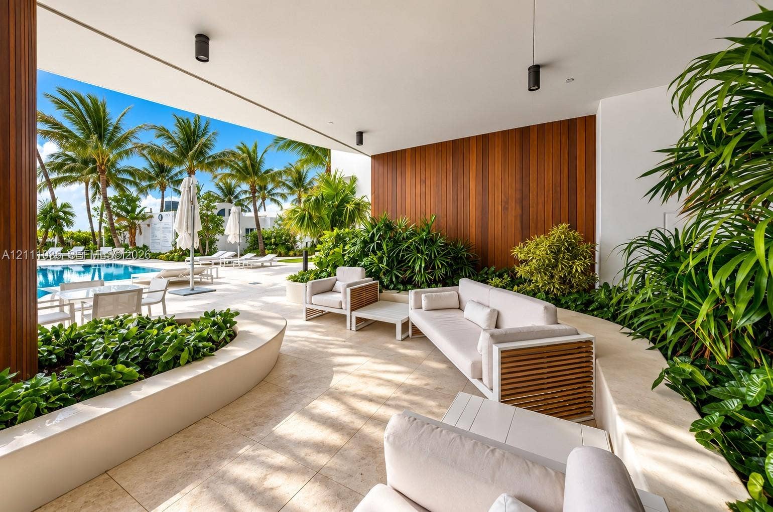 6365 Collins Avenue, #3811, Miami Beach, FL 33141 Covered patio featuring large-format stone tile flooring, vertical wood-panel accent wall, integrated recessed lighting, and built-in curved stone planters