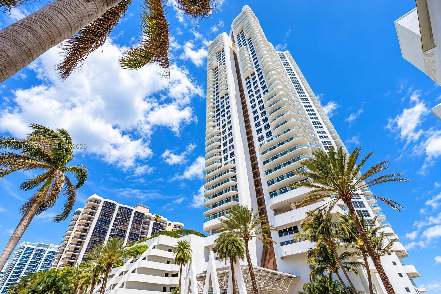 6365 Collins Avenue, #3811, Miami Beach, FL 33141 High-rise tower featuring a white concrete facade, recessed glass-paneled balconies, and architectural structural elements