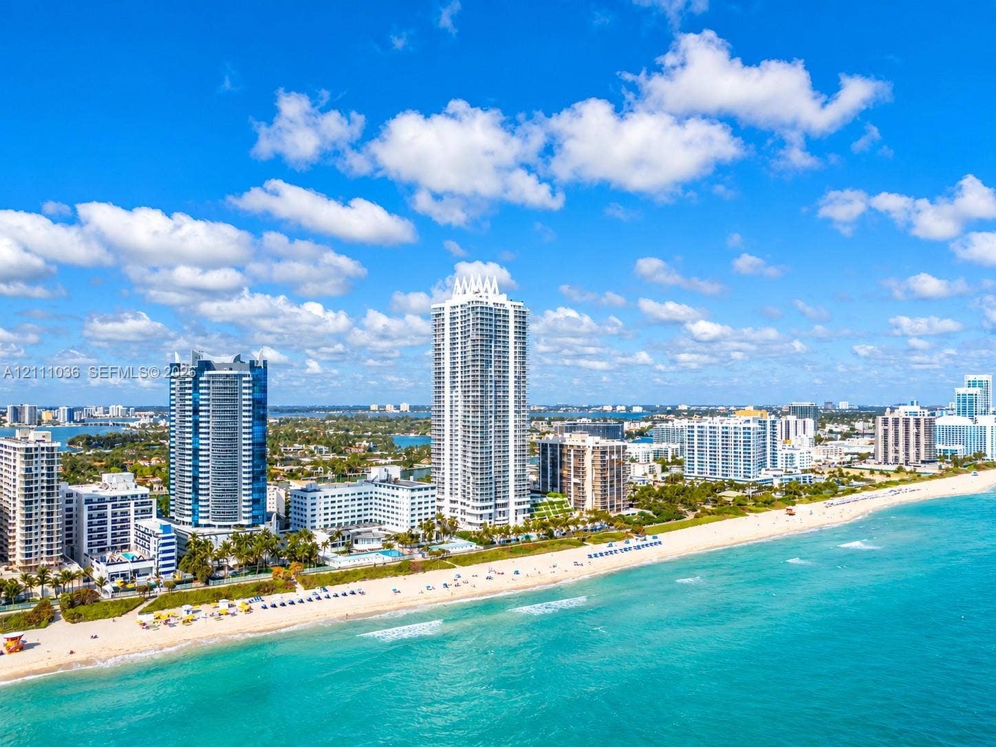6365 Collins Avenue, #3811, Miami Beach, FL 33141 Aerial perspective of coastal high-rise towers positioned along a sandy shoreline with direct oceanfront exposure