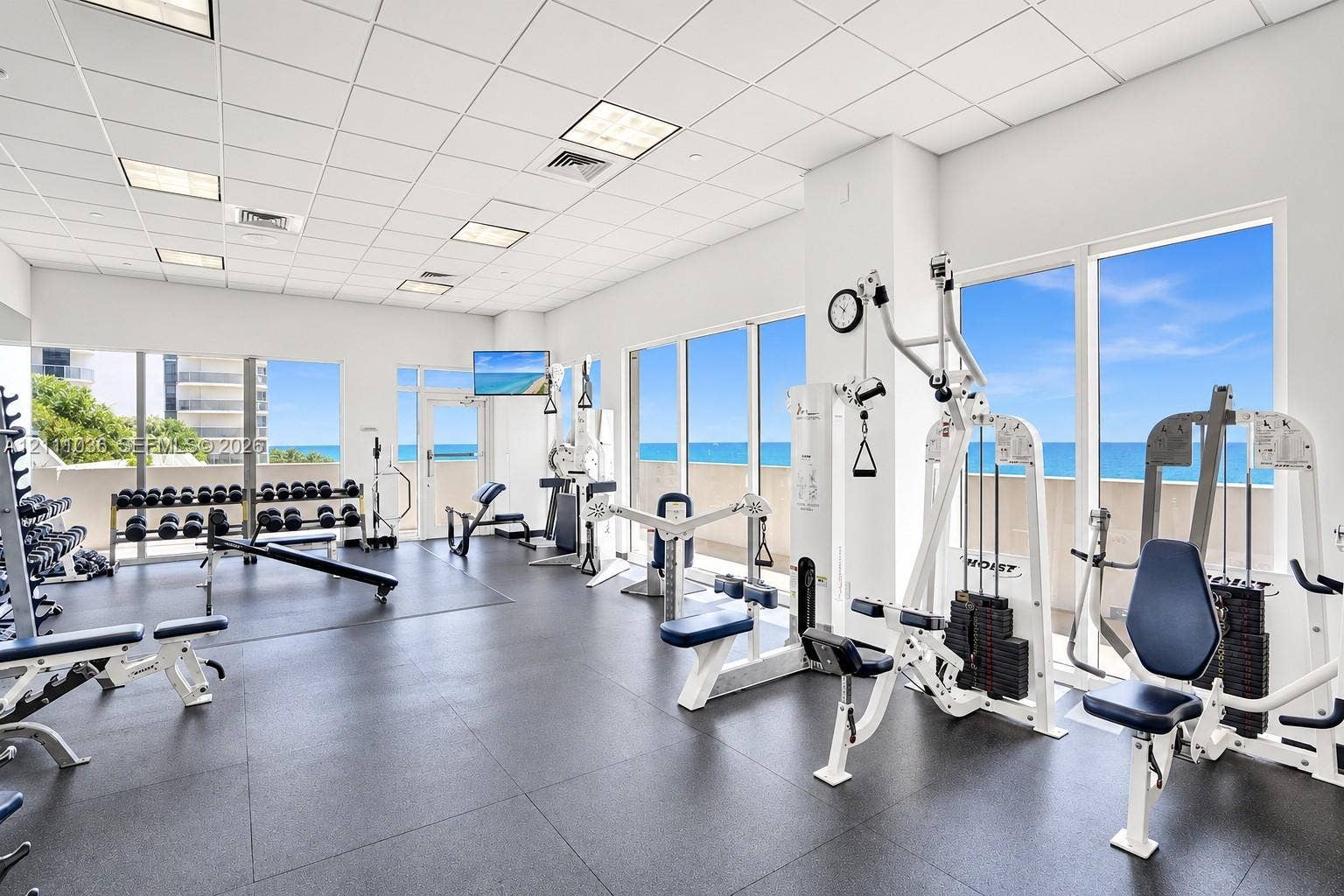 6365 Collins Avenue, #3811, Miami Beach, FL 33141 Fitness center featuring floor-to-ceiling windows, ocean horizon backdrop, drop-ceiling grid, and durable rubberized flooring