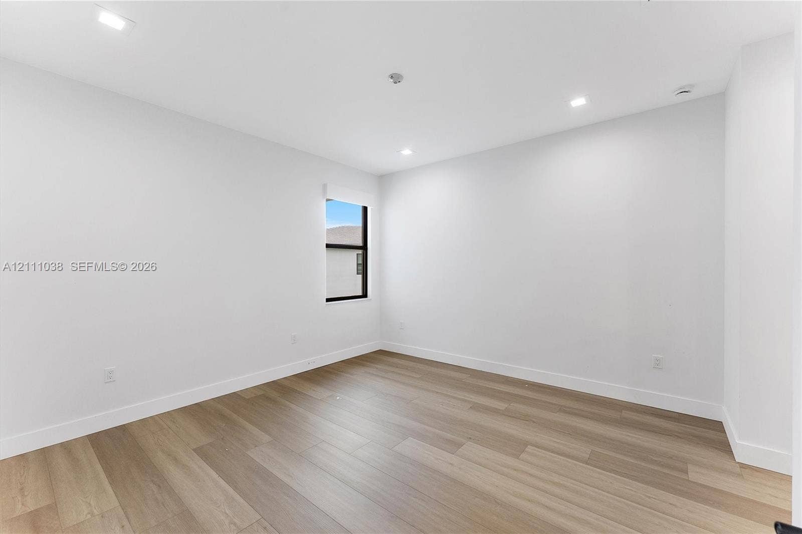 Interior space featuring wood-finish flooring, recessed lighting, and a window with a dark frame
