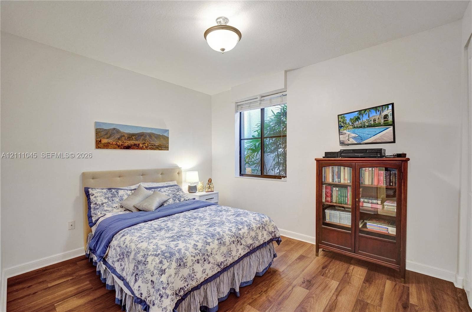 2901 NW 126th Avenue, #2-225, Sunrise, FL 33323 Room featuring wood-finish flooring, neutral walls, a single-pane window, and a central ceiling-mounted light fixture