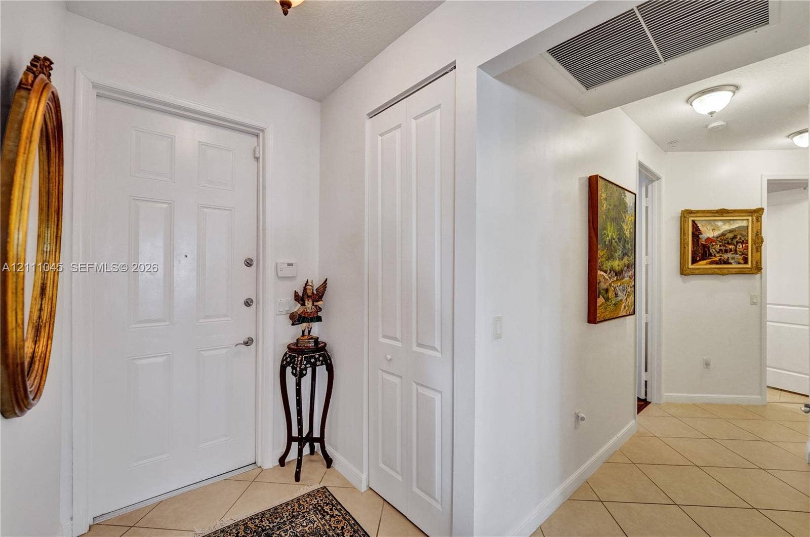 2901 NW 126th Avenue, #2-225, Sunrise, FL 33323 Entry foyer featuring a white paneled door, ceramic tile flooring, and closet with white bi-fold doors, accented by ceiling-mounted lighting