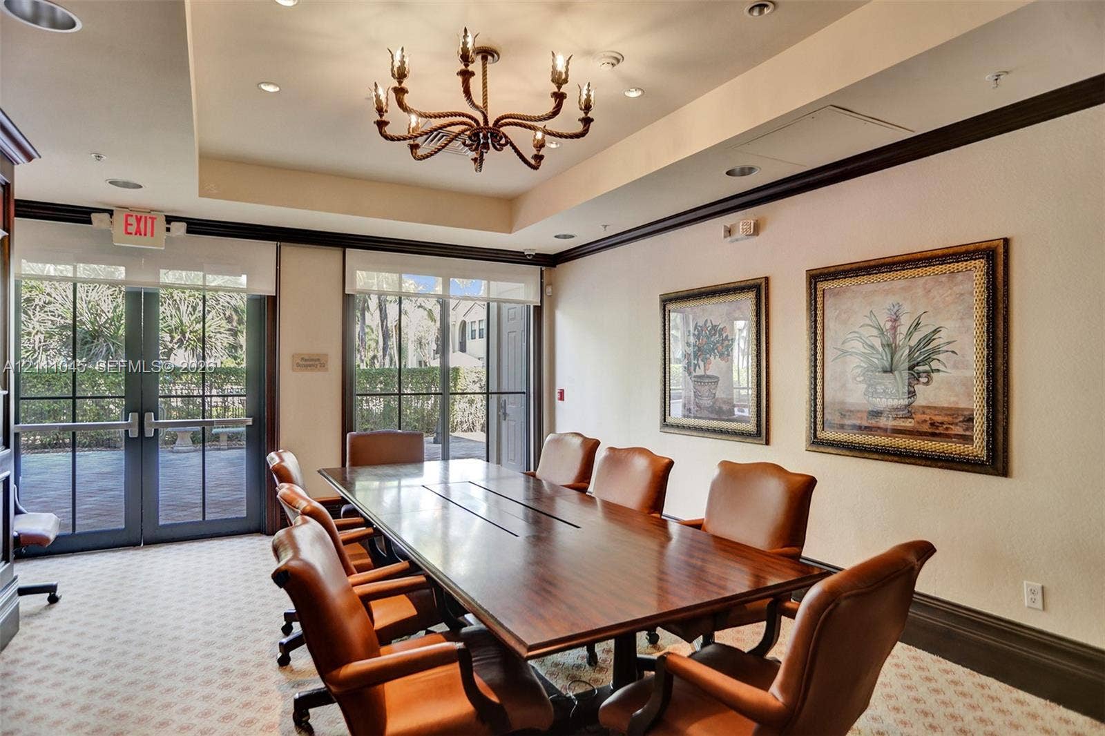 2901 NW 126th Avenue, #2-225, Sunrise, FL 33323 Conference room featuring a tray ceiling, decorative metal chandelier, crown molding, and floor-to-ceiling glass-paned doors