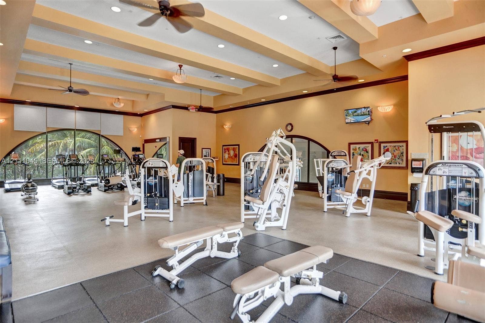 2901 NW 126th Avenue, #2-225, Sunrise, FL 33323 Fitness center featuring coffered ceilings, recessed lighting, multiple ceiling fans, arched windows, and multi-surface flooring