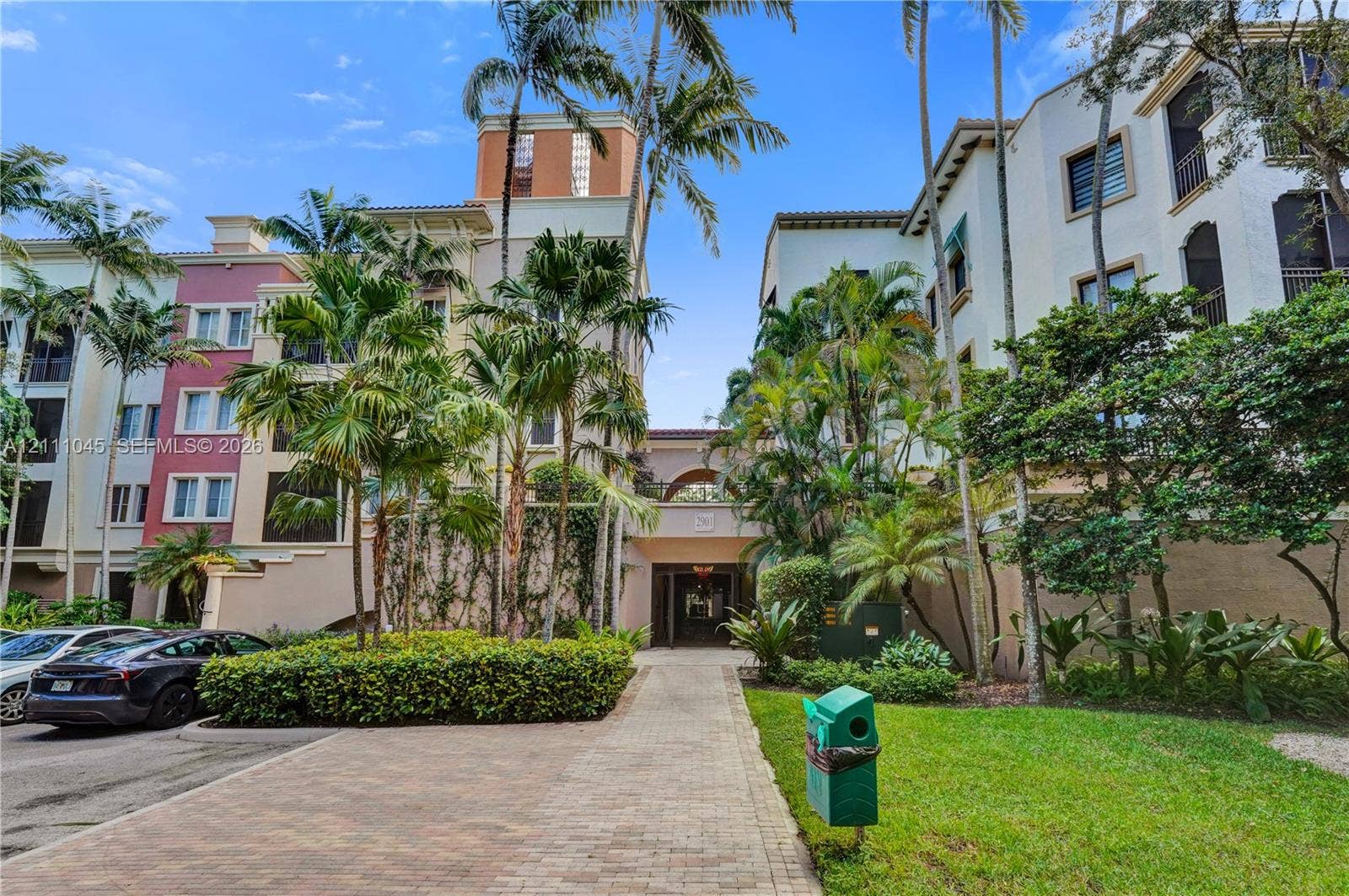 2901 NW 126th Avenue, #2-225, Sunrise, FL 33323 Multi-story Mediterranean-inspired exterior featuring stucco facades, arched architectural details, mature palm trees, and brick paver walkways