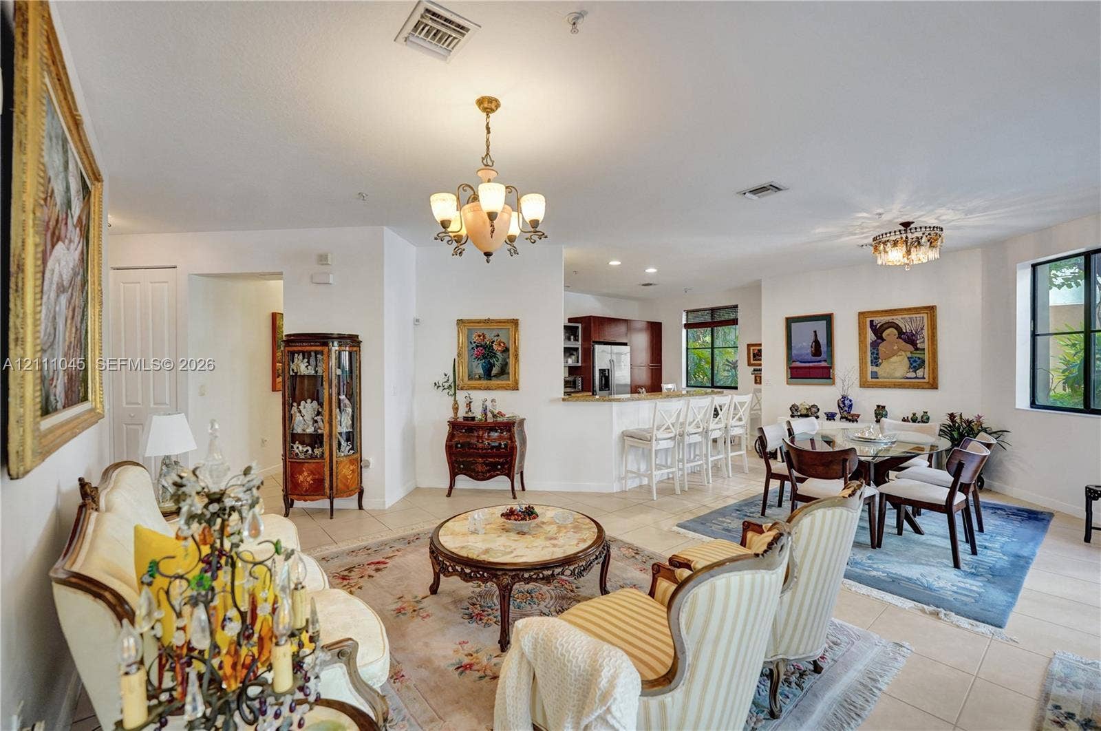 2901 NW 126th Avenue, #2-225, Sunrise, FL 33323 Open-concept interior featuring light-toned tile flooring, recessed lighting, and dual multi-arm chandeliers