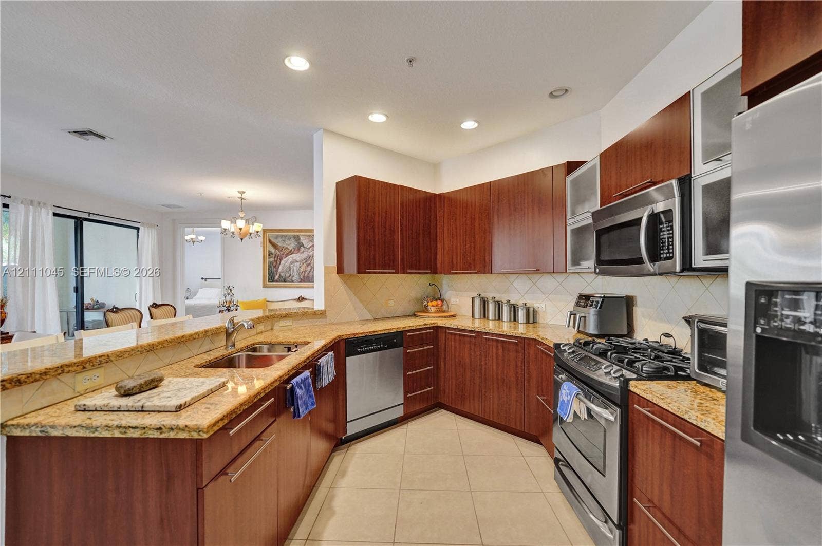 2901 NW 126th Avenue, #2-225, Sunrise, FL 33323 Kitchen featuring flat-panel wood cabinetry, stone countertops, tiled backsplash, stainless steel appliances, and recessed lighting
