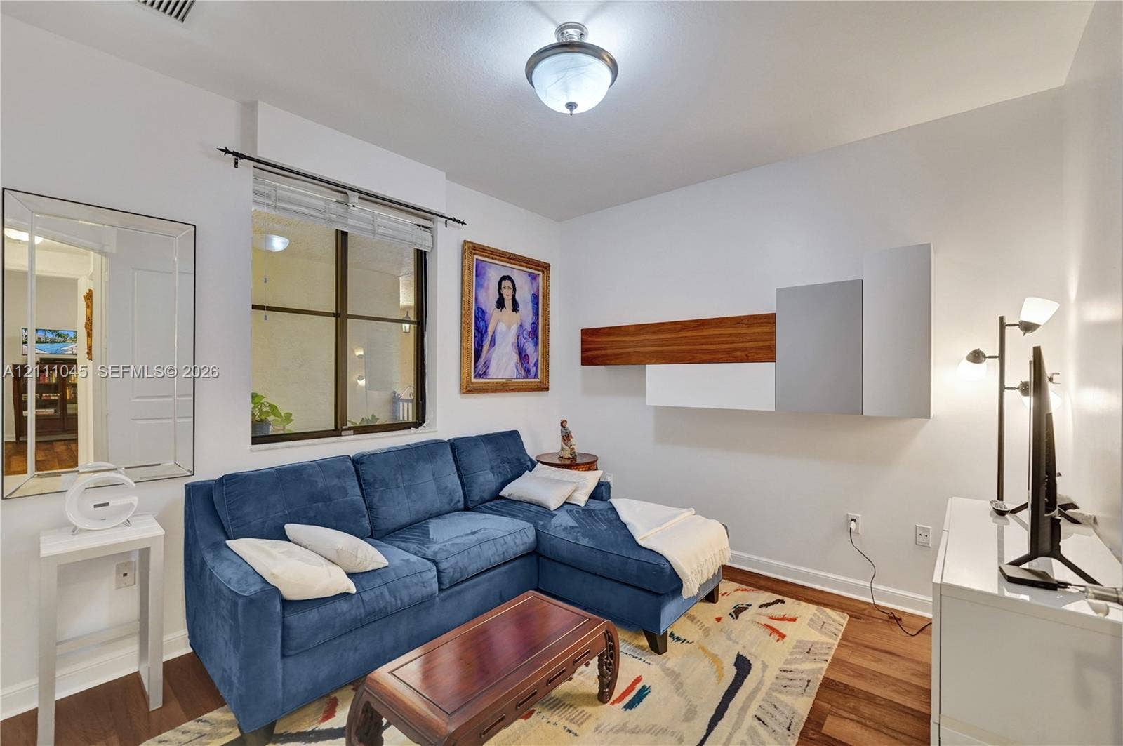 2901 NW 126th Avenue, #2-225, Sunrise, FL 33323 Wall-mounted contemporary cabinetry with wood-finish and matte-finish panels, flush-mount lighting, and wood-finish flooring