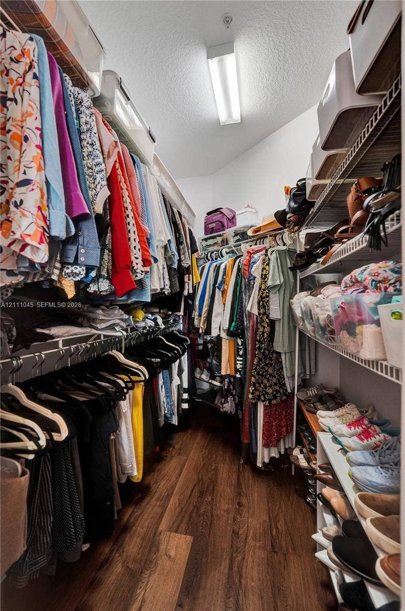 2901 NW 126th Avenue, #2-225, Sunrise, FL 33323 Walk-in closet featuring wood-finish flooring, tiered wire shelving, and overhead linear lighting