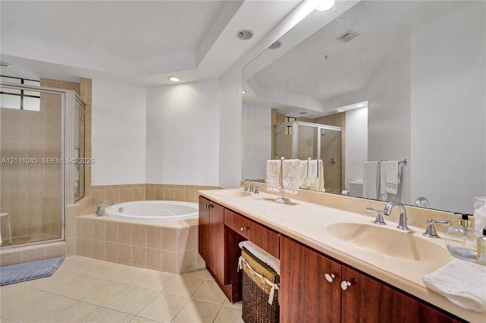 2901 NW 126th Avenue, #2-225, Sunrise, FL 33323 Bathroom featuring a jetted soaking tub, tiled shower enclosure, expansive dual-sink vanity with wood-finish cabinetry, and recessed lighting