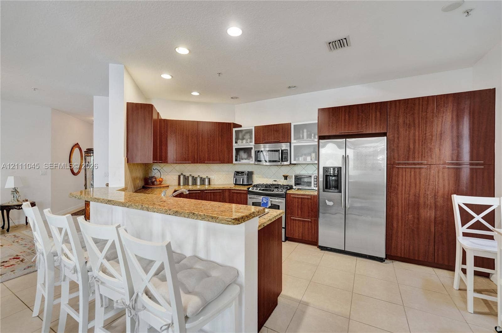 2901 NW 126th Avenue, #2-225, Sunrise, FL 33323 Kitchen featuring dark wood-finish cabinetry, stone-surface countertops, stainless steel appliances, recessed ceiling lighting, and tile flooring