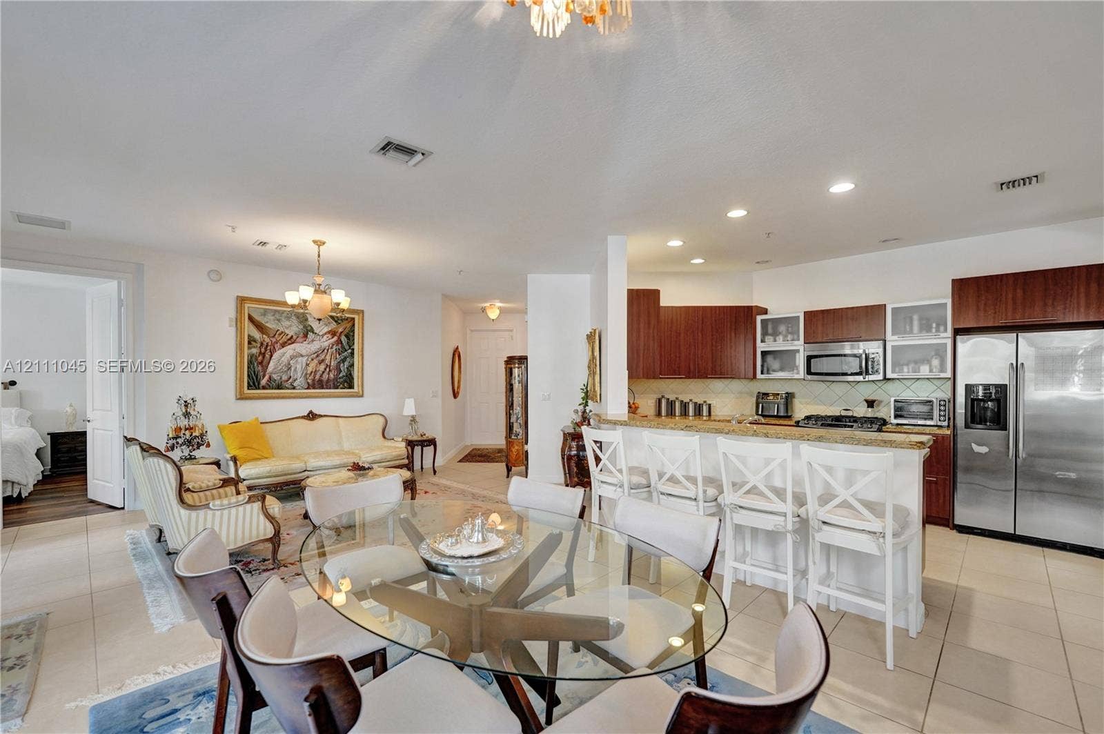 2901 NW 126th Avenue, #2-225, Sunrise, FL 33323 Open-concept interior featuring light-toned tile flooring, recessed ceiling lighting, a kitchen island with stone countertops, and wood-finish cabinetry
