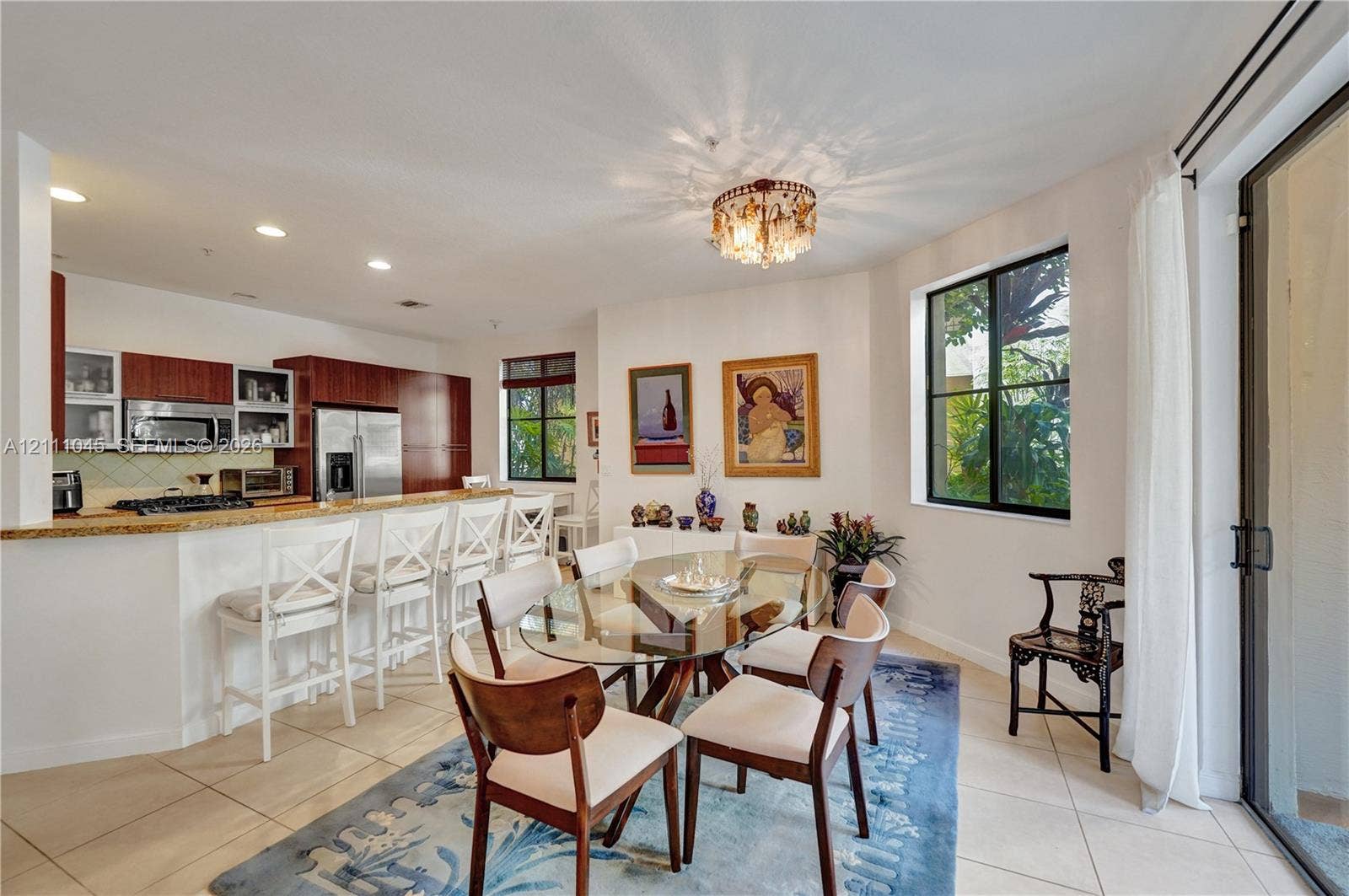 2901 NW 126th Avenue, #2-225, Sunrise, FL 33323 Kitchen featuring a stone-surface breakfast bar, dark-finish cabinetry, recessed lighting, tile flooring, and a decorative flush-mount fixture