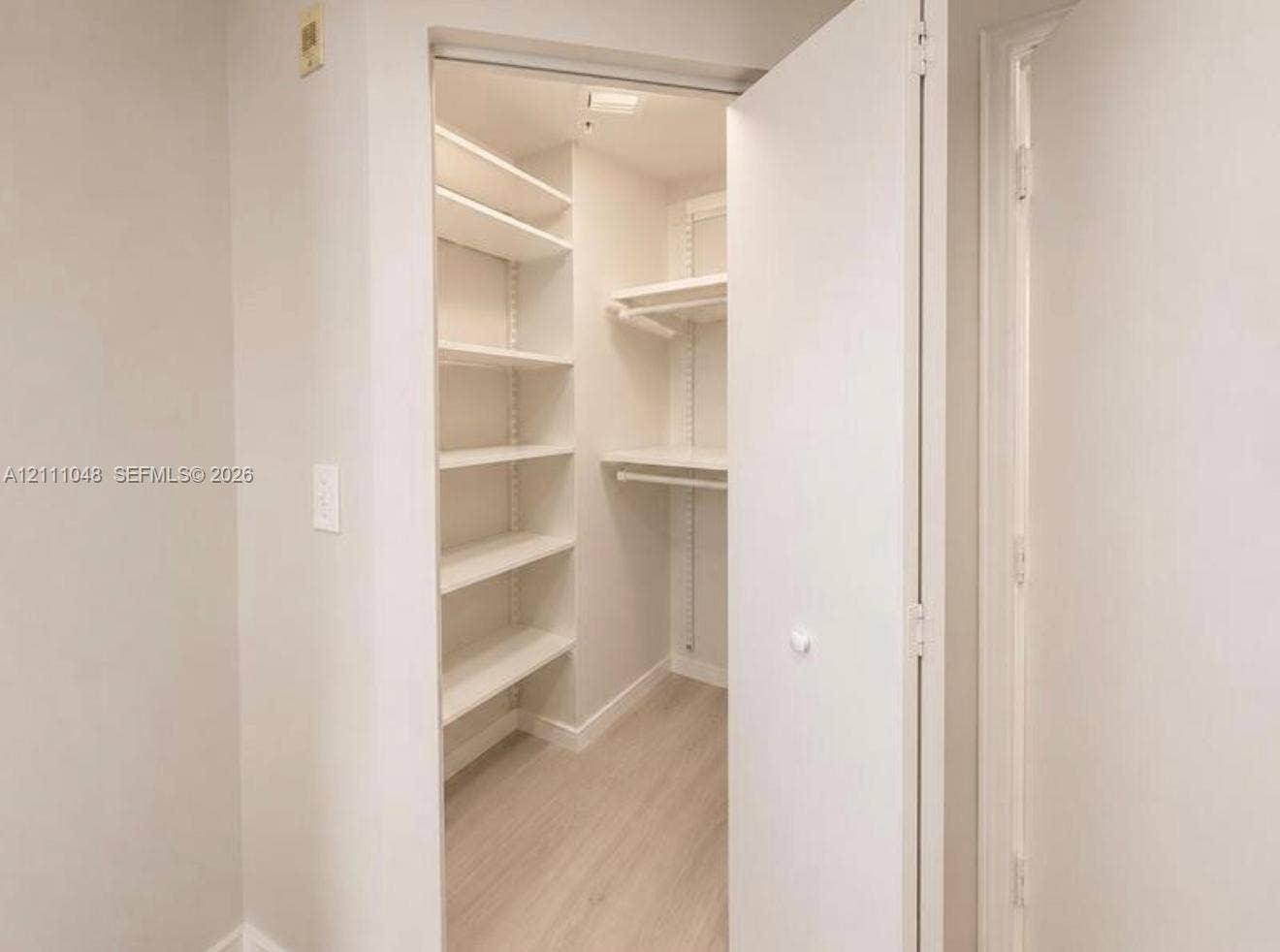 2775 NE 187th Street, #408, Aventura, Aventura, FL 33180 Reach-in closet featuring adjustable shelving, integrated hanging rods, and light-toned wood-finish flooring