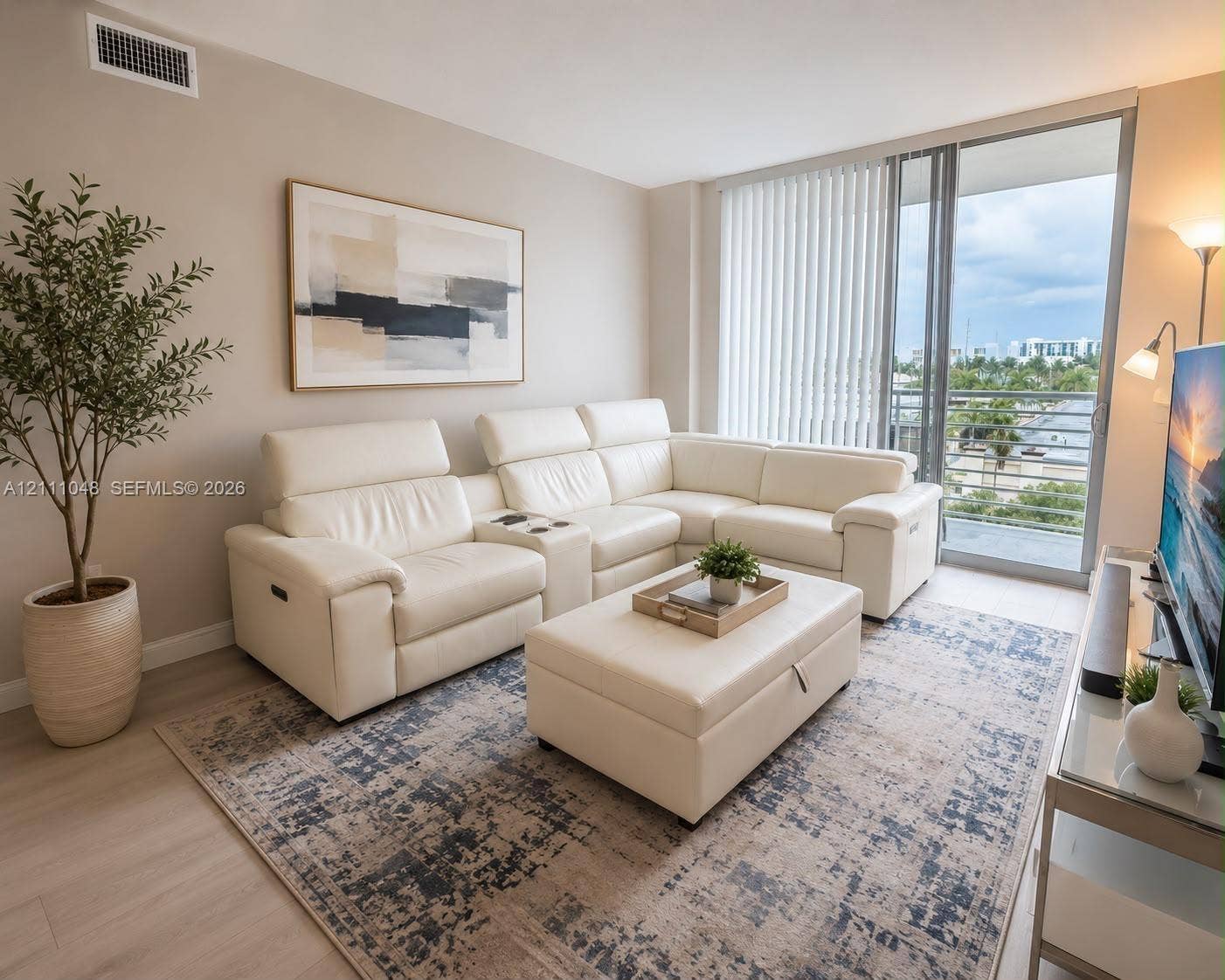 2775 NE 187th Street, #408, Aventura, Aventura, FL 33180 Living area featuring neutral wall paint, wood-finish flooring, and a glass sliding door providing exterior access