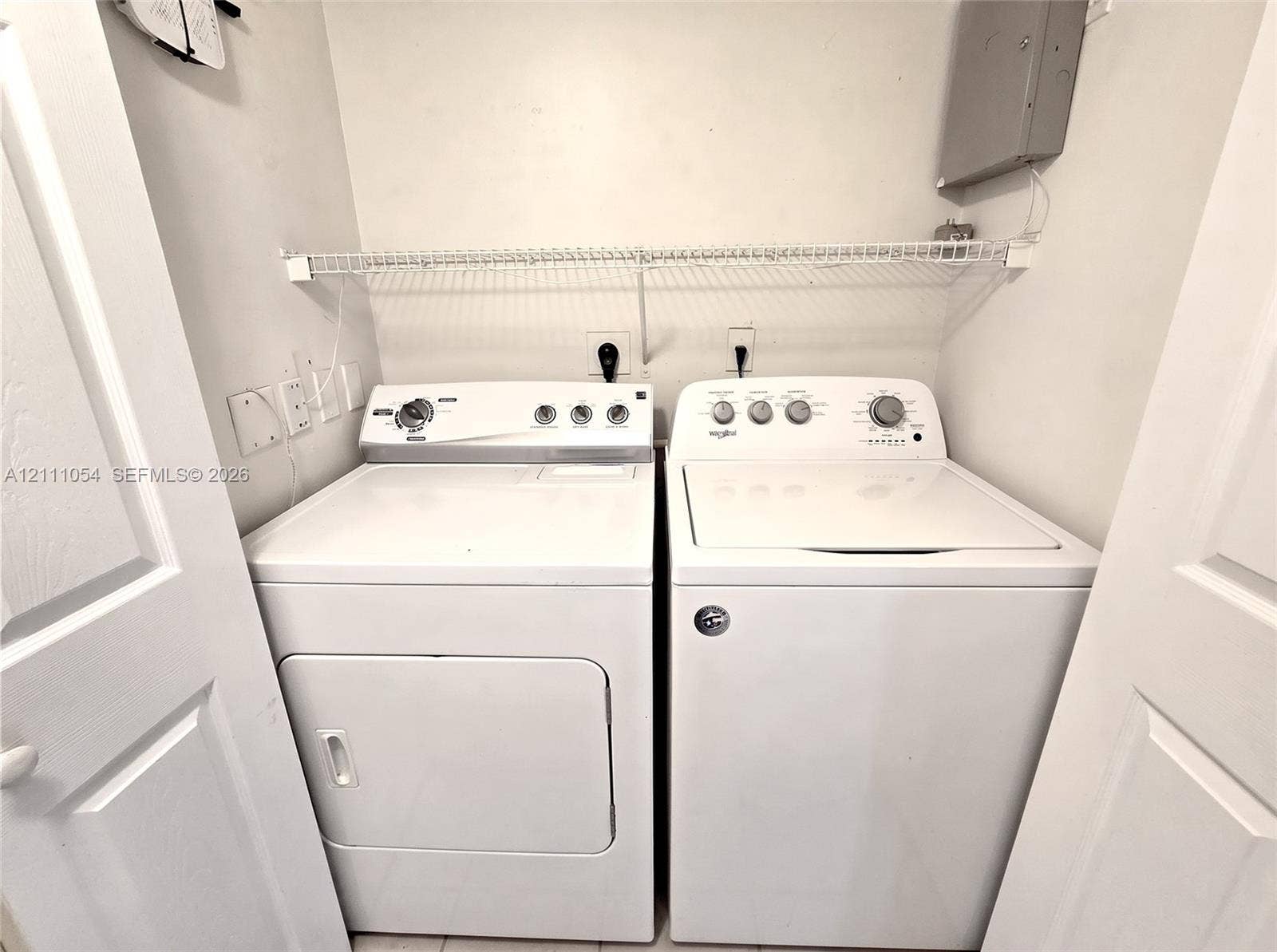 4180 San Marino Boulevard, #106, West Palm Beach, FL 33409 Laundry closet featuring built-in wire shelving and dual-hinged doors