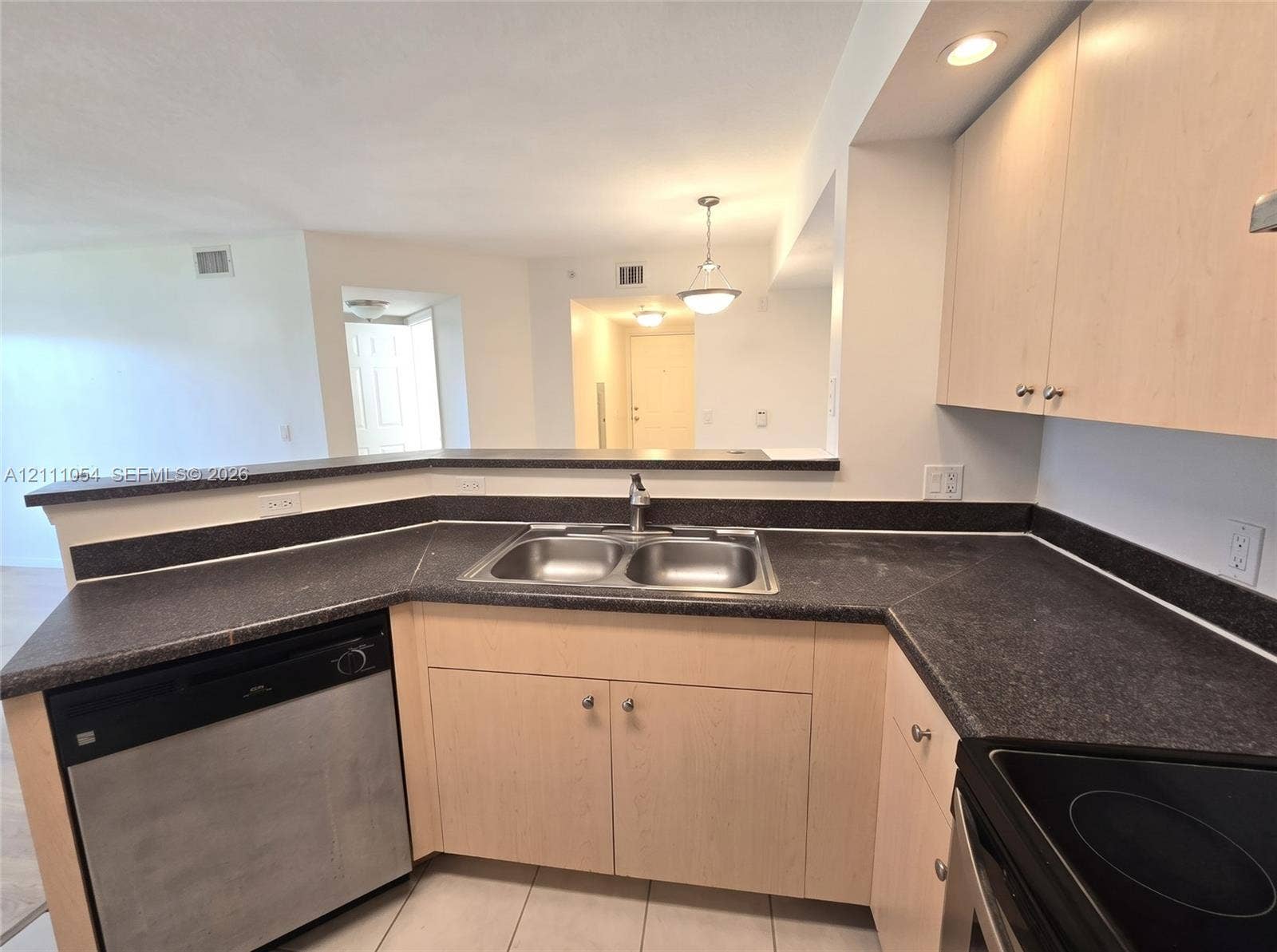 4180 San Marino Boulevard, #106, West Palm Beach, FL 33409 Kitchen featuring light-finish cabinetry, dark solid-surface countertops, stainless steel dual-basin sink, and recessed lighting