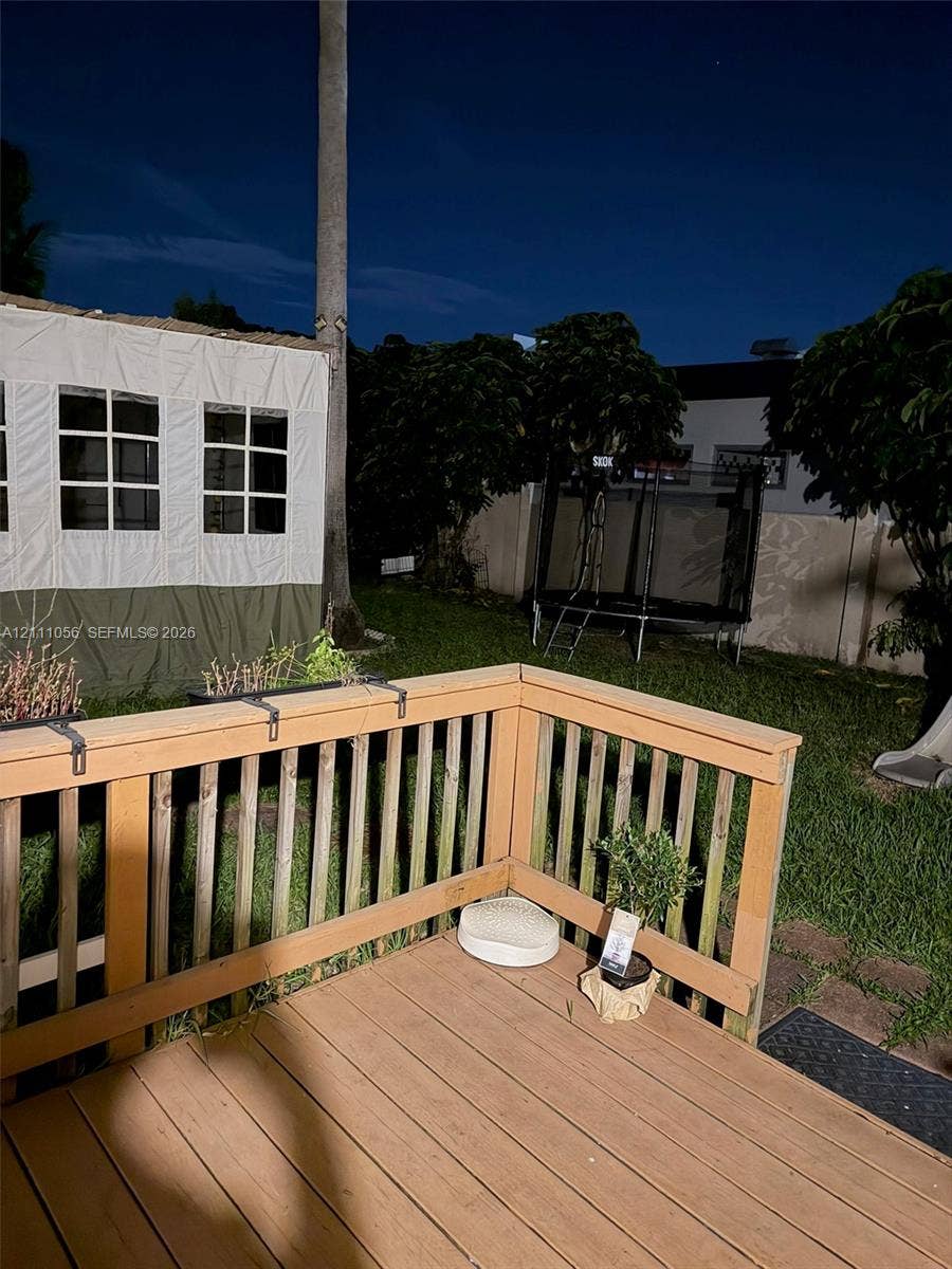 5020 Sheridan Street, #2, Hollywood, FL 33021 Wooden deck featuring a railing and manicured lawn area